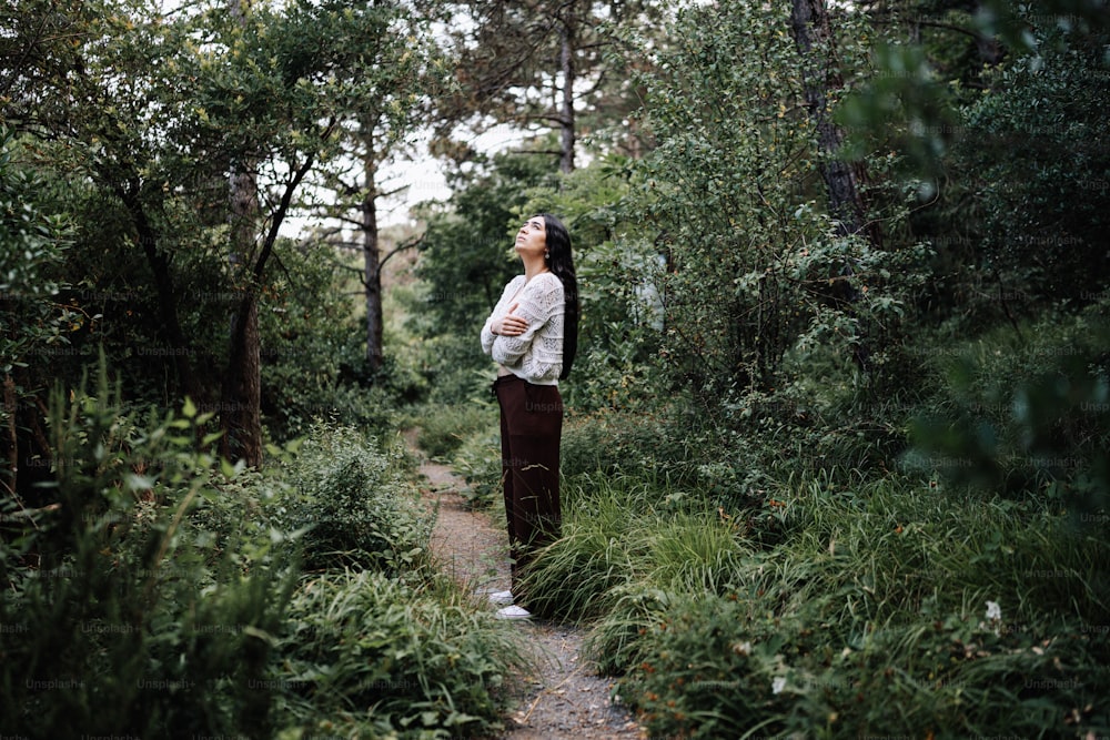 Une femme debout au milieu d’une forêt