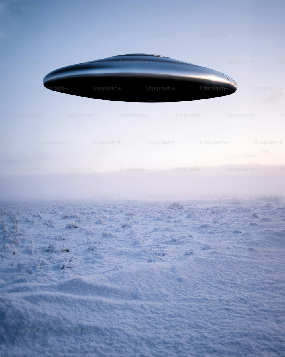 a black object flying over a snow covered field
