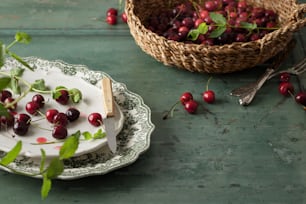 a plate with cherries on it next to a basket of cherries