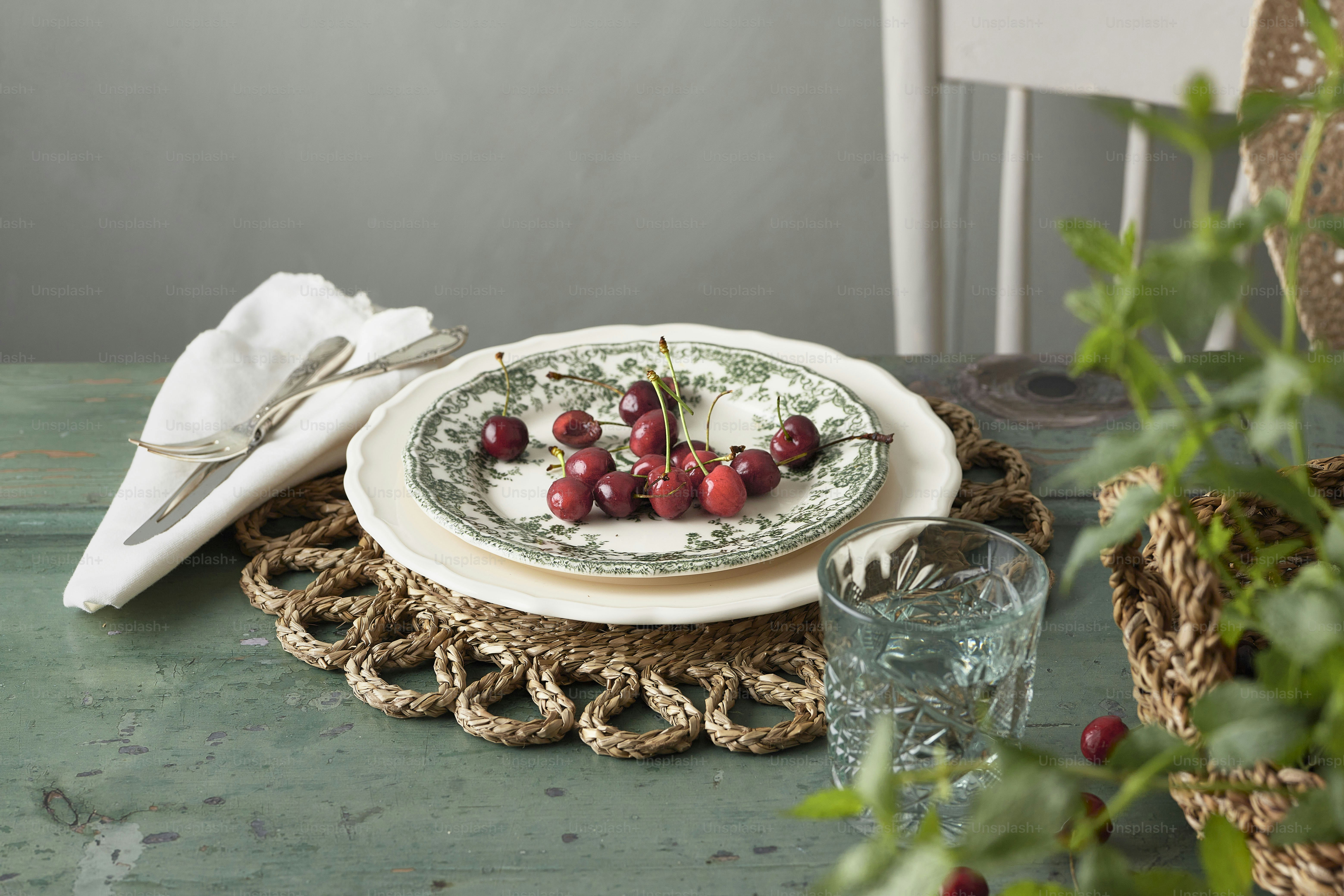 un plato con cerezas sentado sobre una mesa