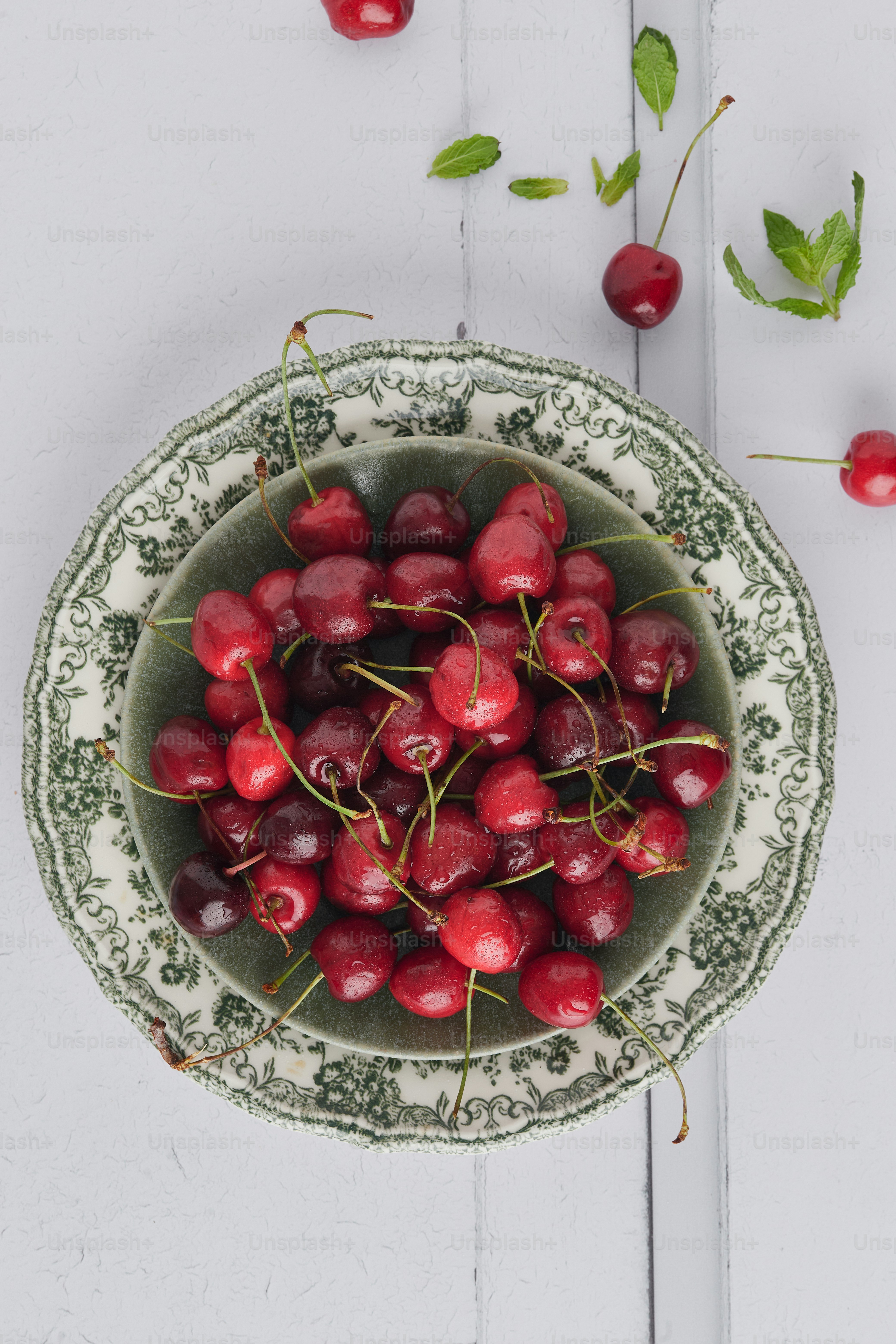 un tazón lleno de cerezas encima de una mesa