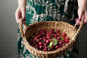 Una donna che tiene un cesto pieno di ciliegie