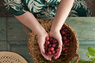 Una donna che tiene un cesto pieno di ciliegie