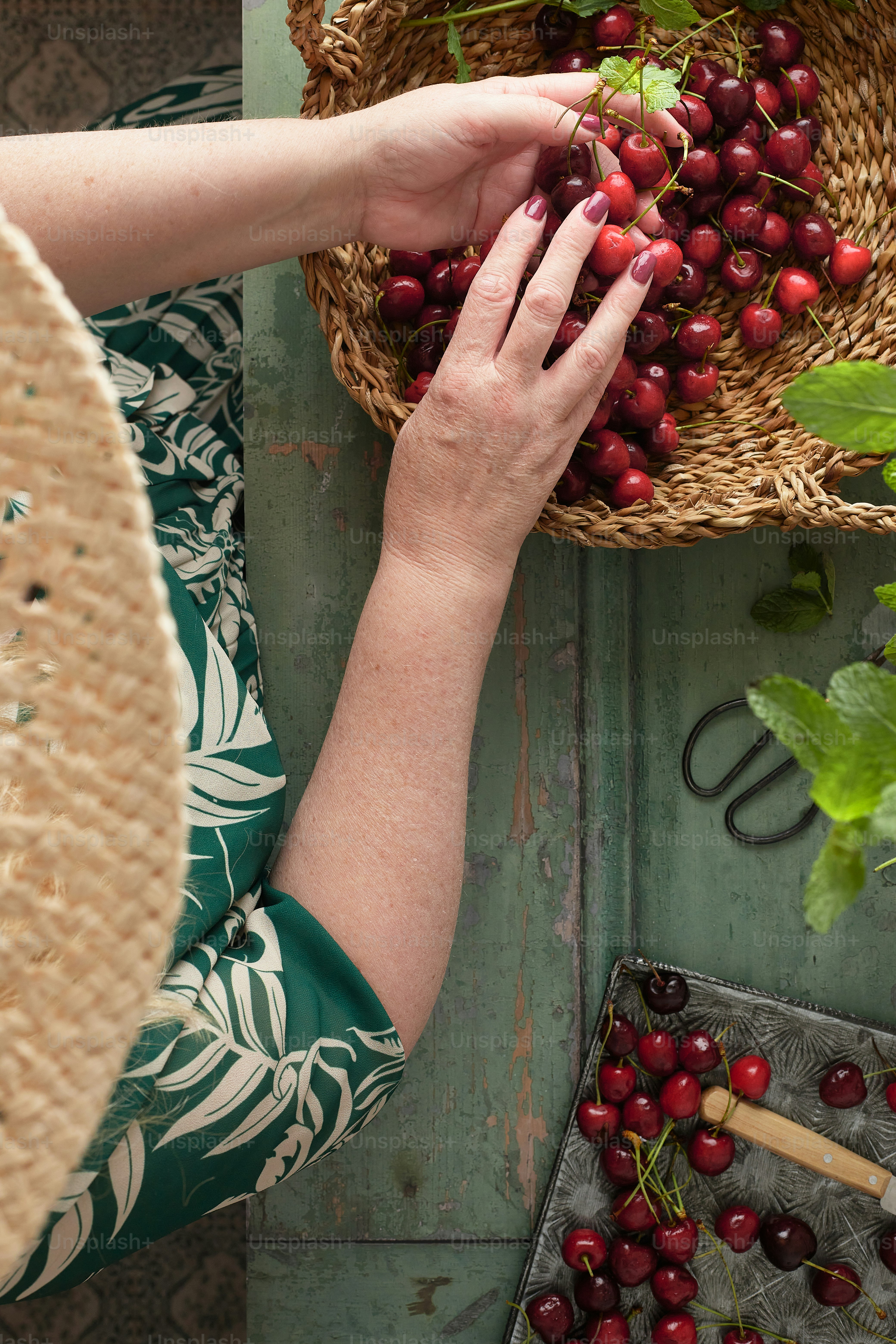 Una mujer sosteniendo una canasta de cerezas en sus manos