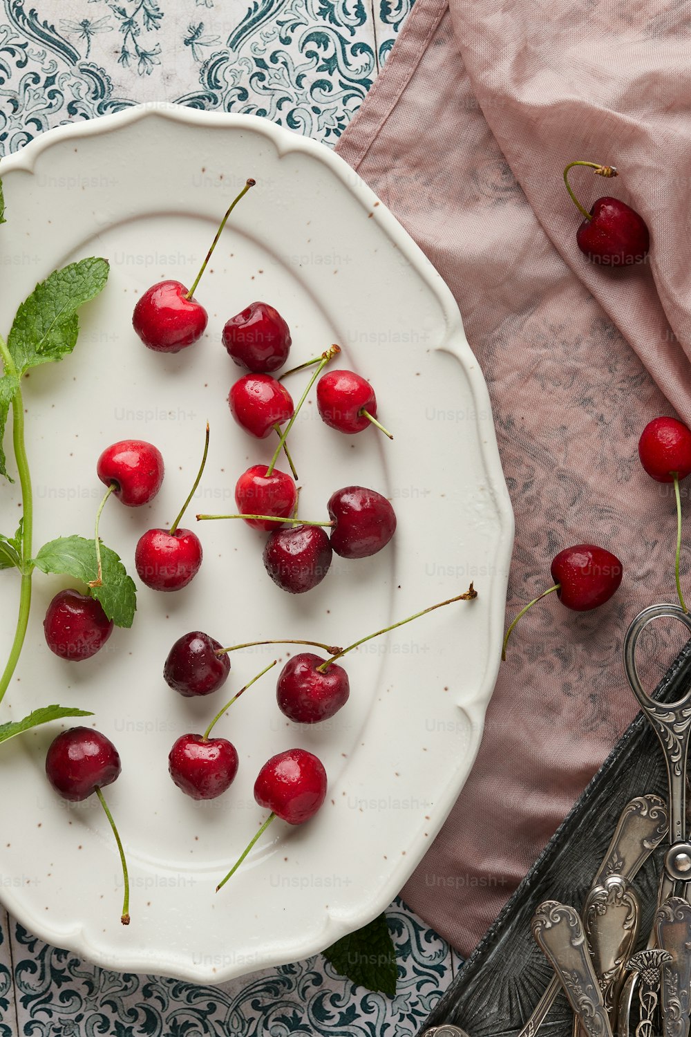 a white plate topped with cherries on top of a table