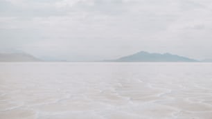 a large body of water with mountains in the background