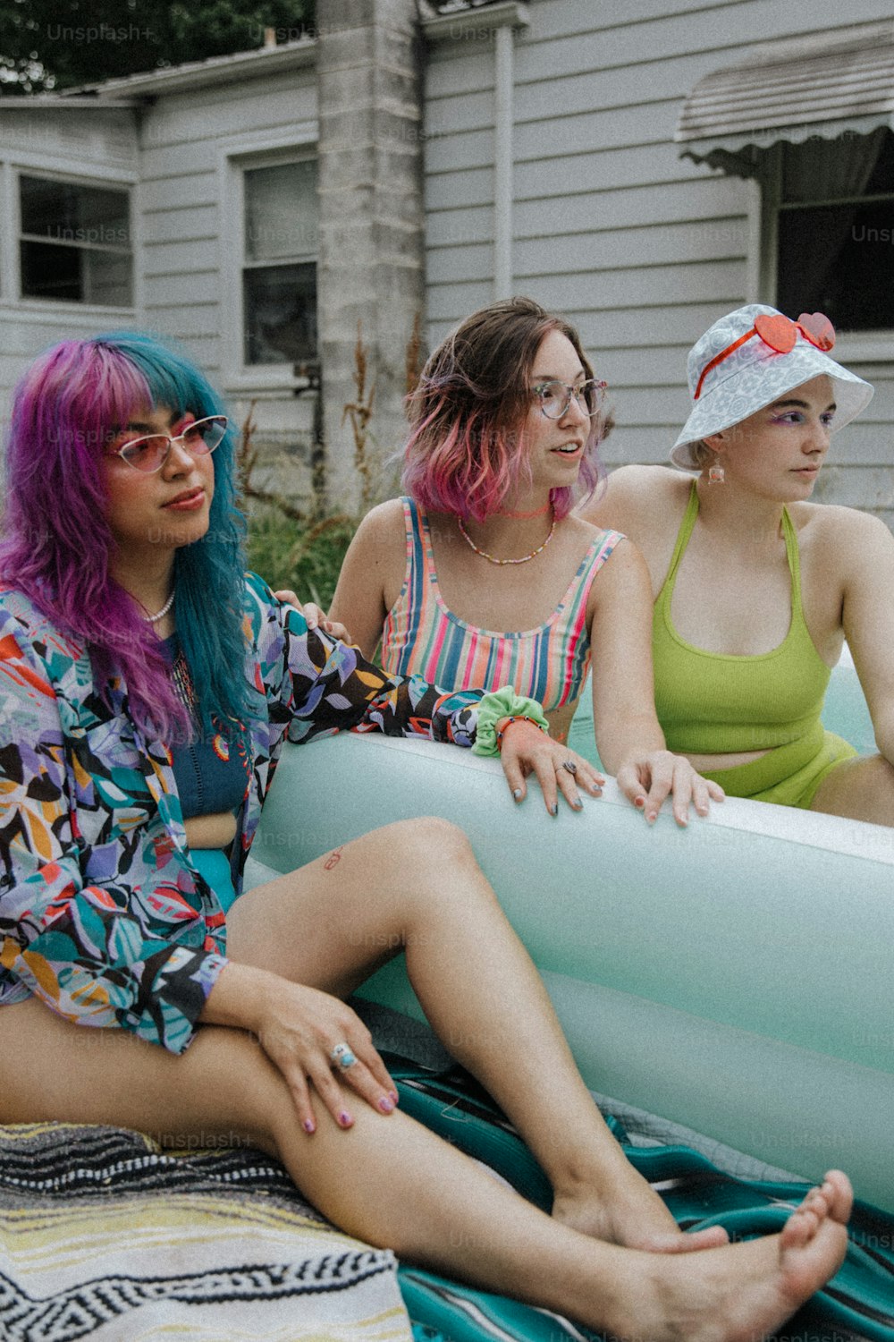 um grupo de mulheres sentadas uma ao lado da outra em uma piscina