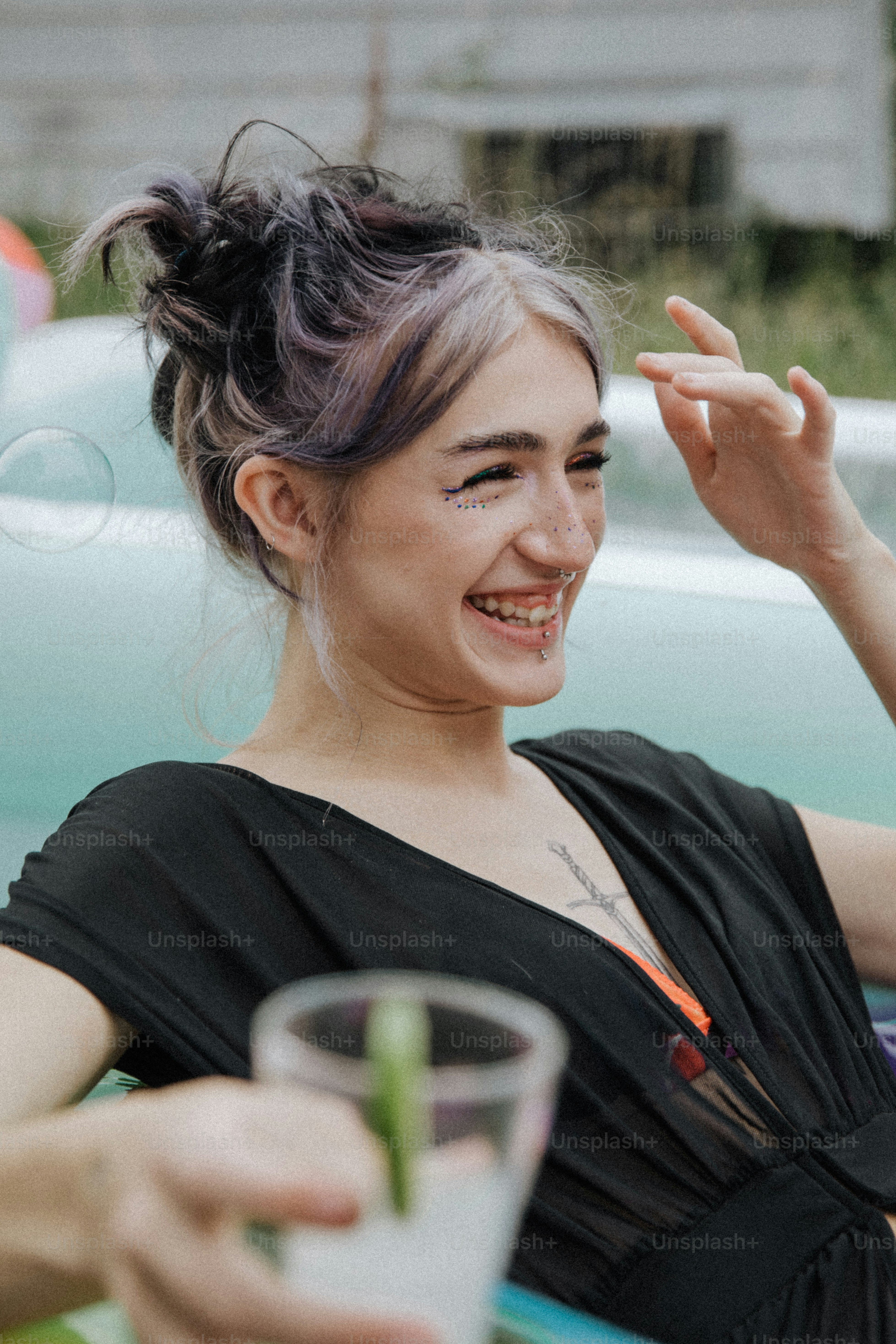 a woman sitting at a table with a drink in her hand