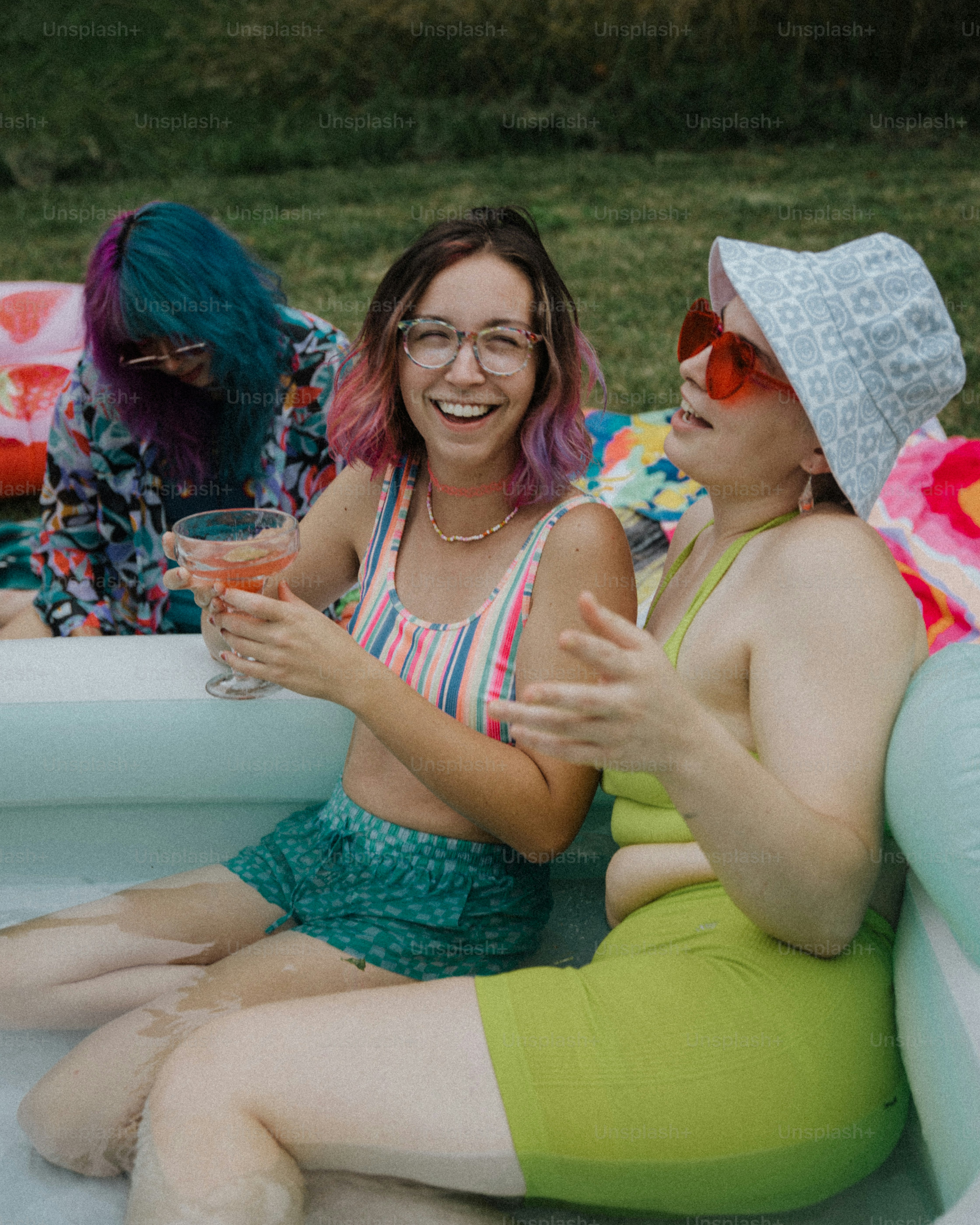 a group of women sitting on top of an inflatable pool