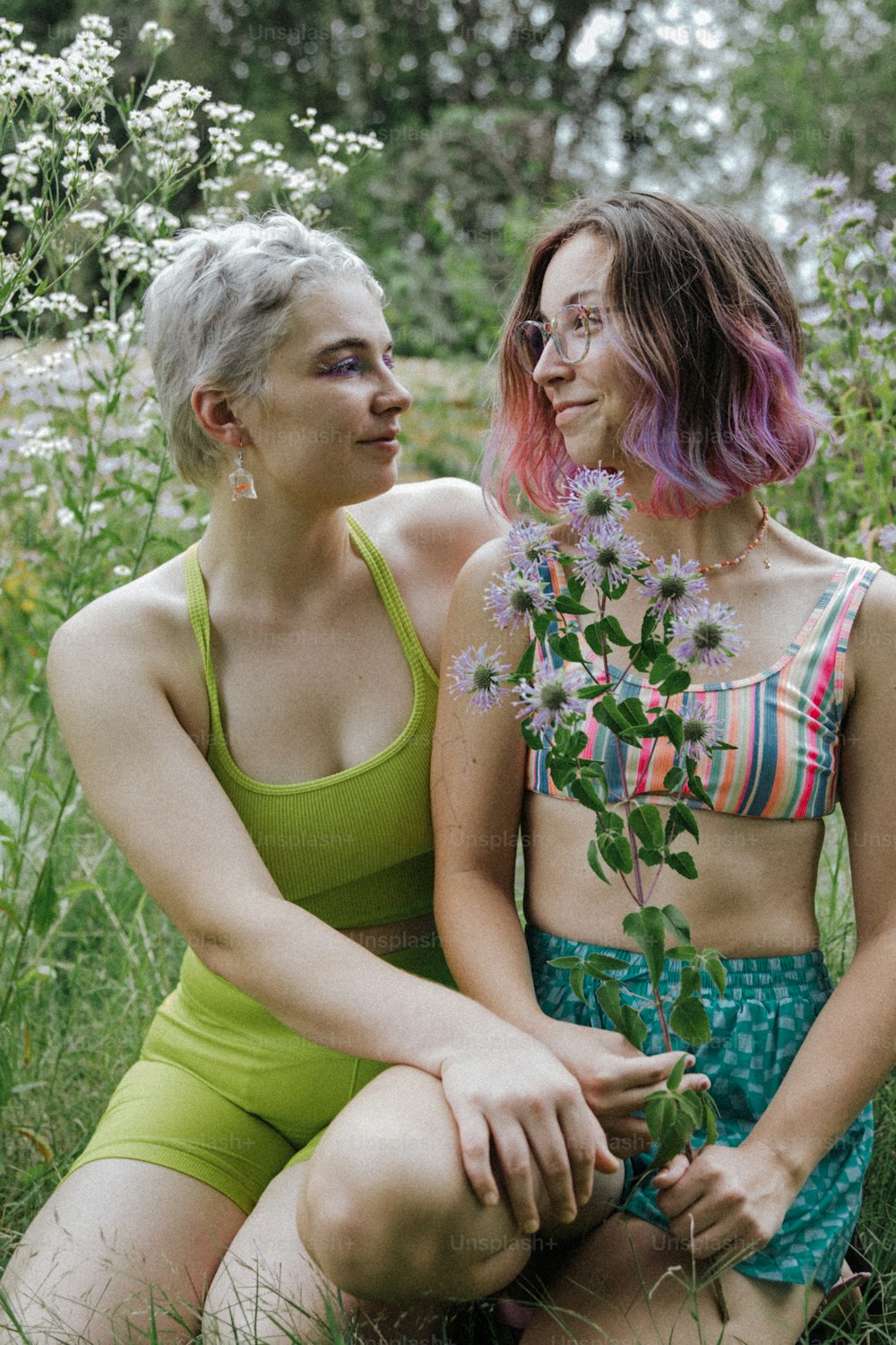 꽃밭에 앉아 있는 두 여자