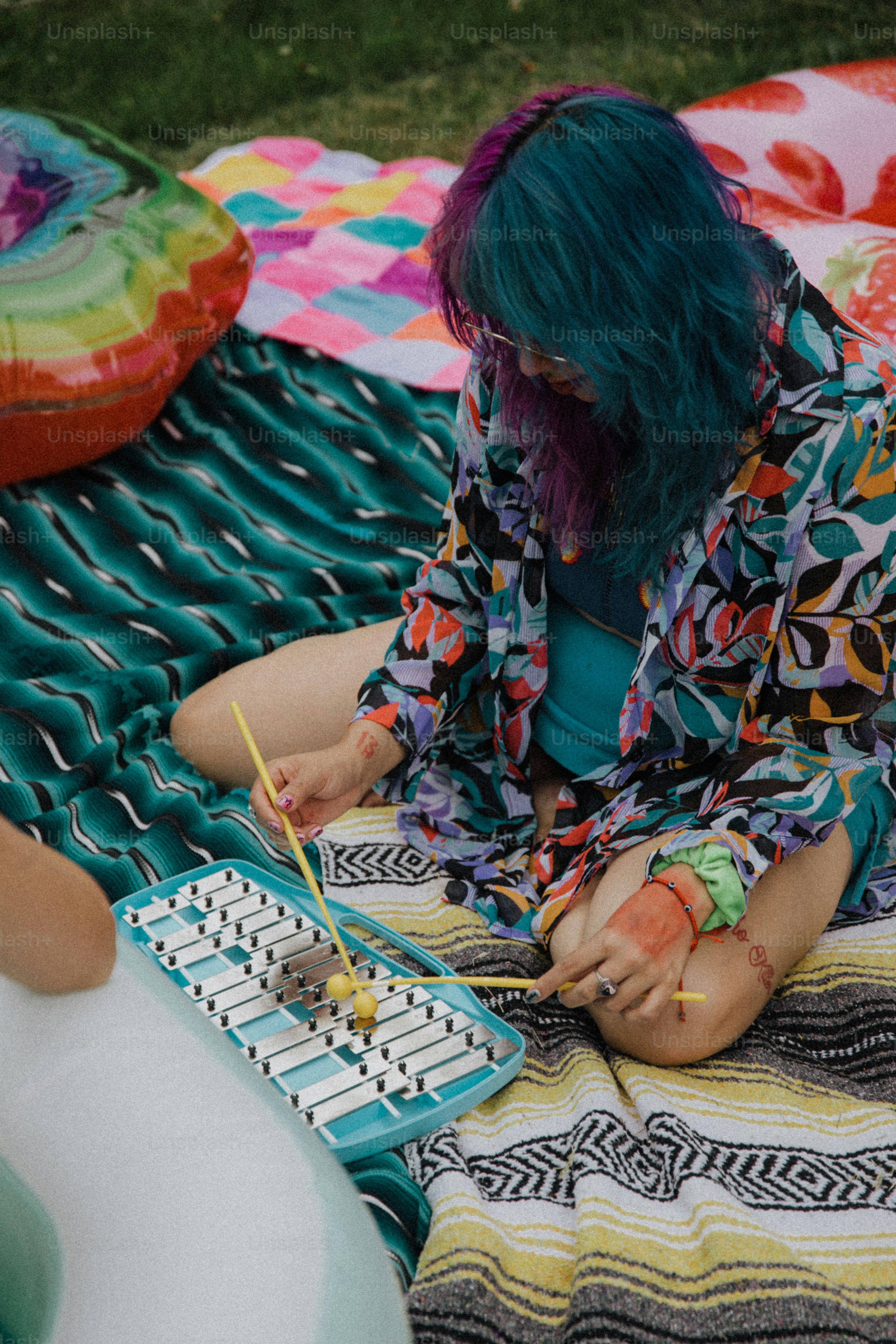 a person sitting on a blanket with a keyboard