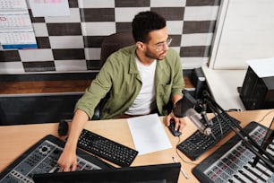 a man sitting at a desk in front of a microphone