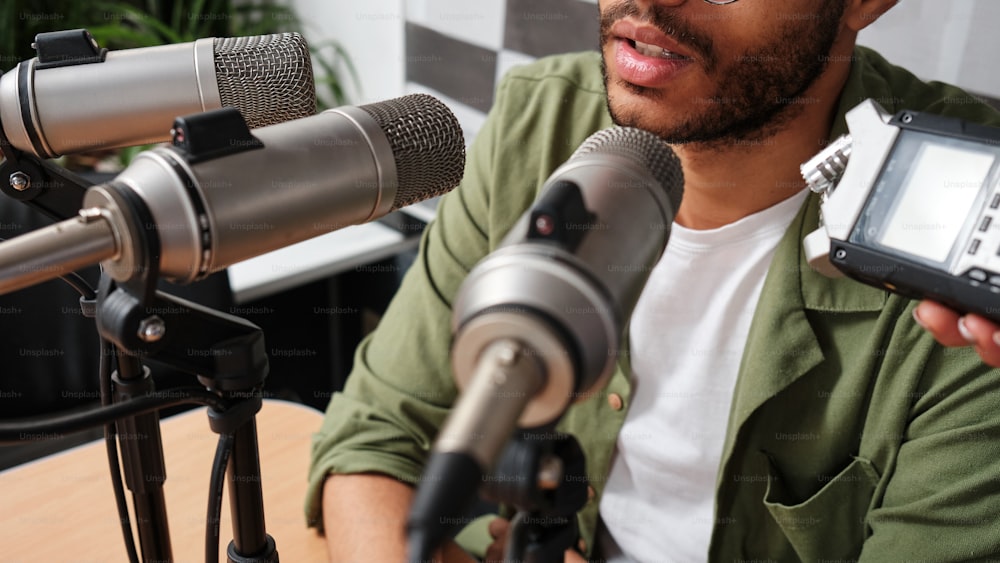 a man holding a cell phone in front of a microphone