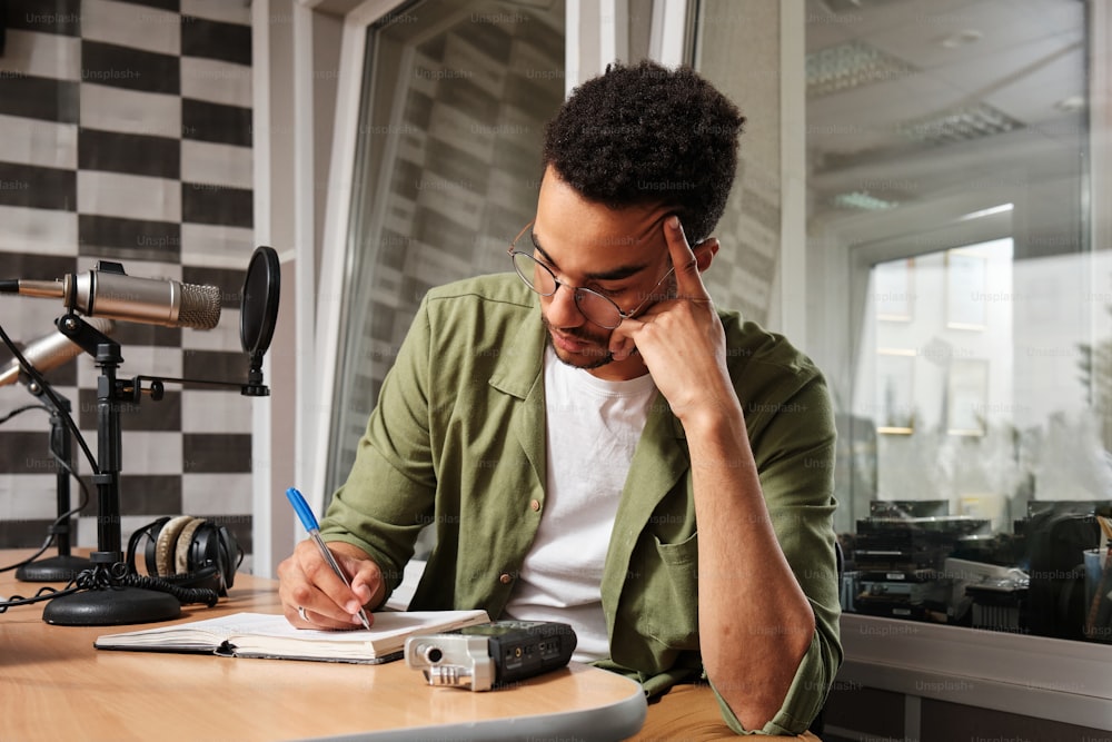 a man sitting at a desk writing on a piece of paper