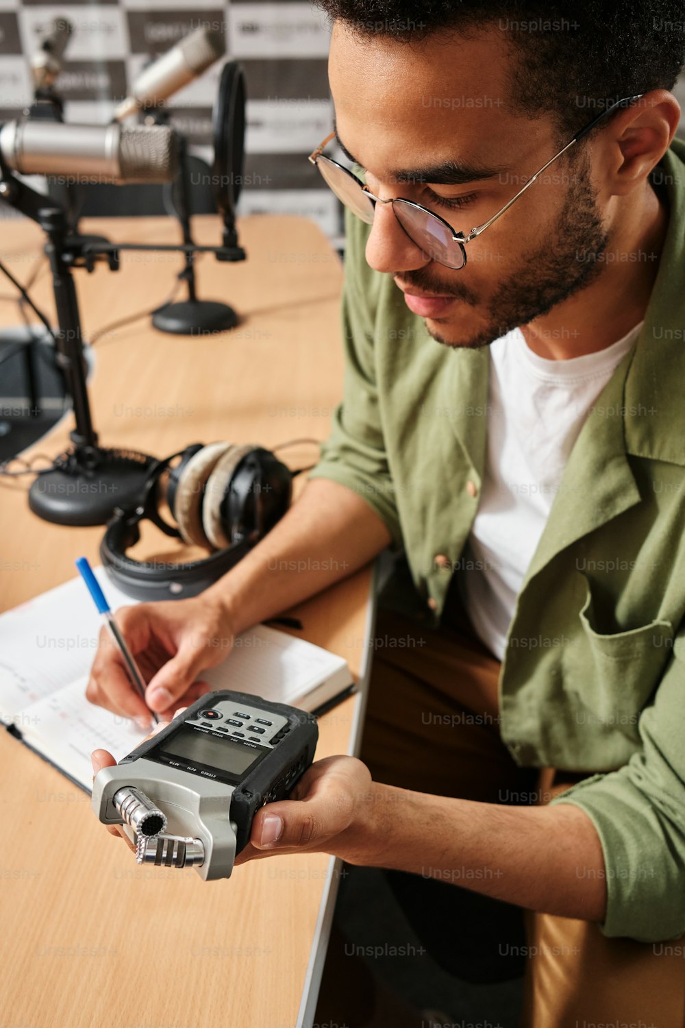 a man sitting at a desk looking at a cell phone