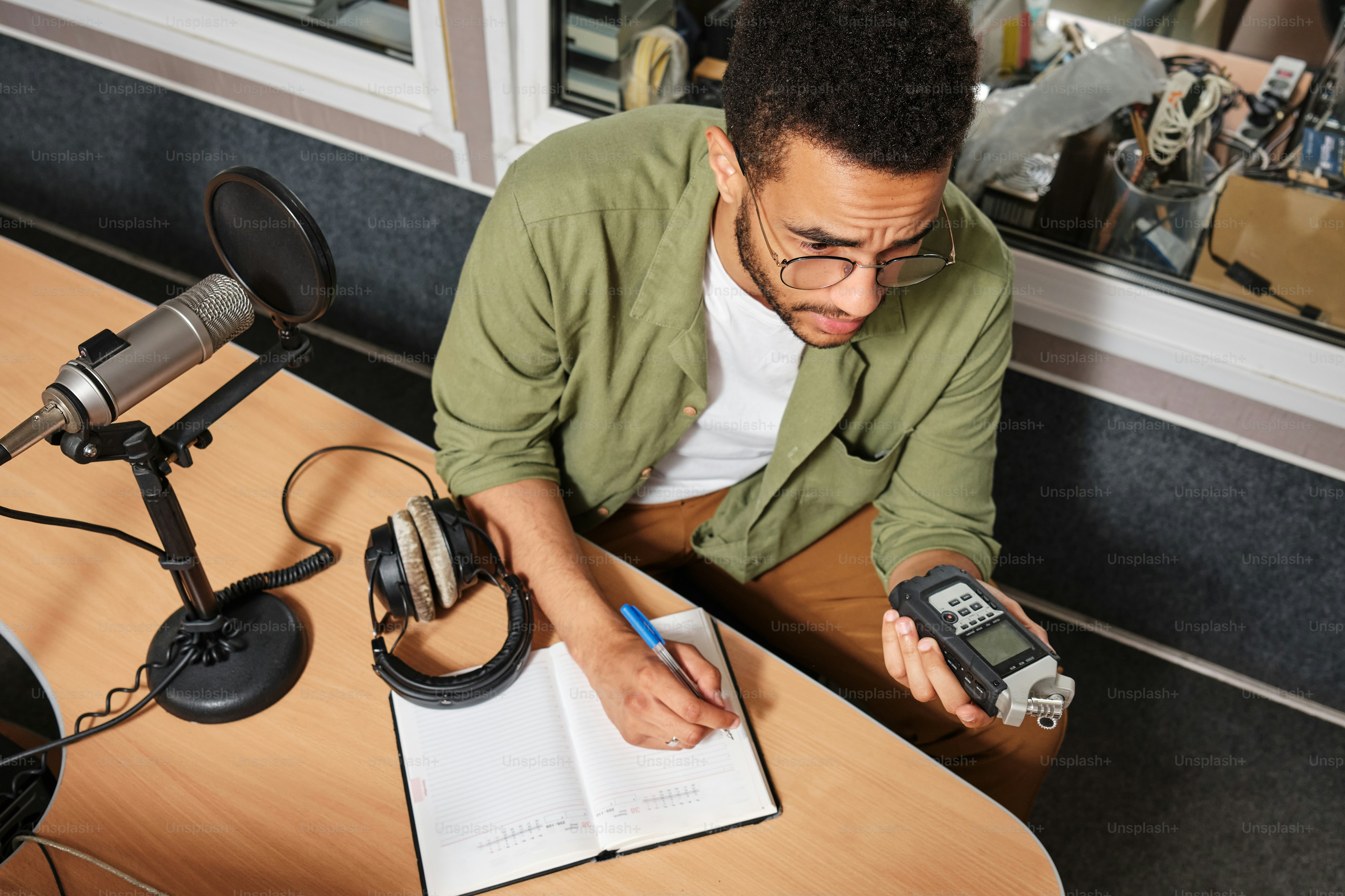 a man sitting at a desk with a book and a cell phone