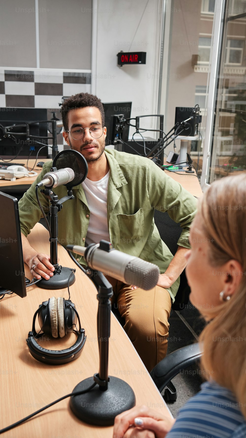 a man sitting in front of a microphone next to a woman
