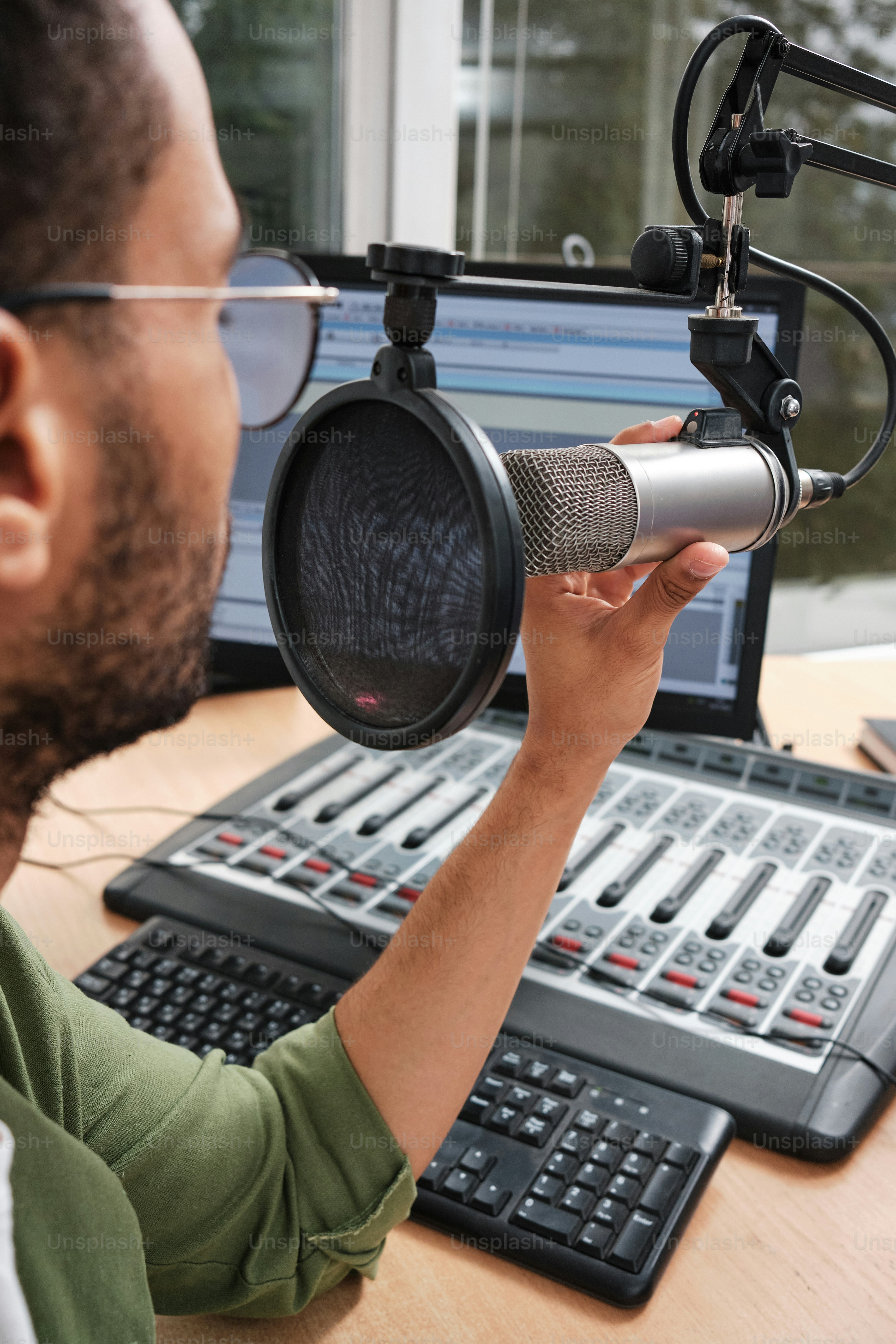 Ein Mann, der ein Mikrofon vor einem Computer hält