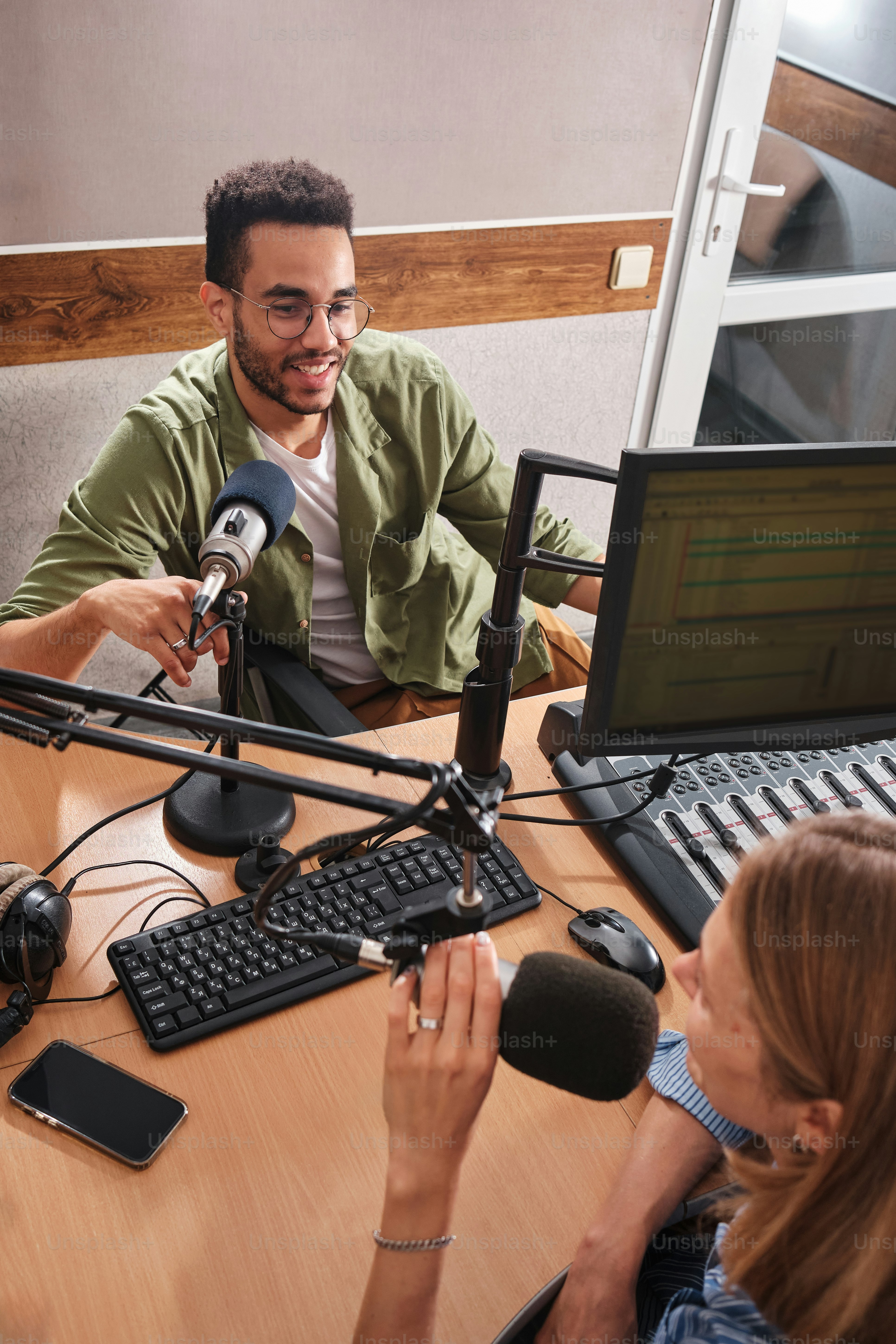 a man and a woman sitting in front of a microphone