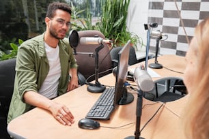um homem sentado em uma mesa em frente a um computador