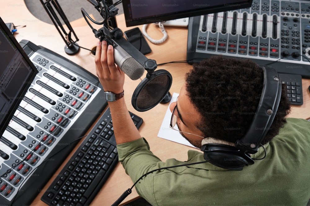 a man sitting at a desk in front of a microphone