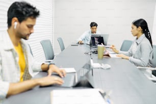 eine gruppe von menschen, die um einen konferenztisch sitzen