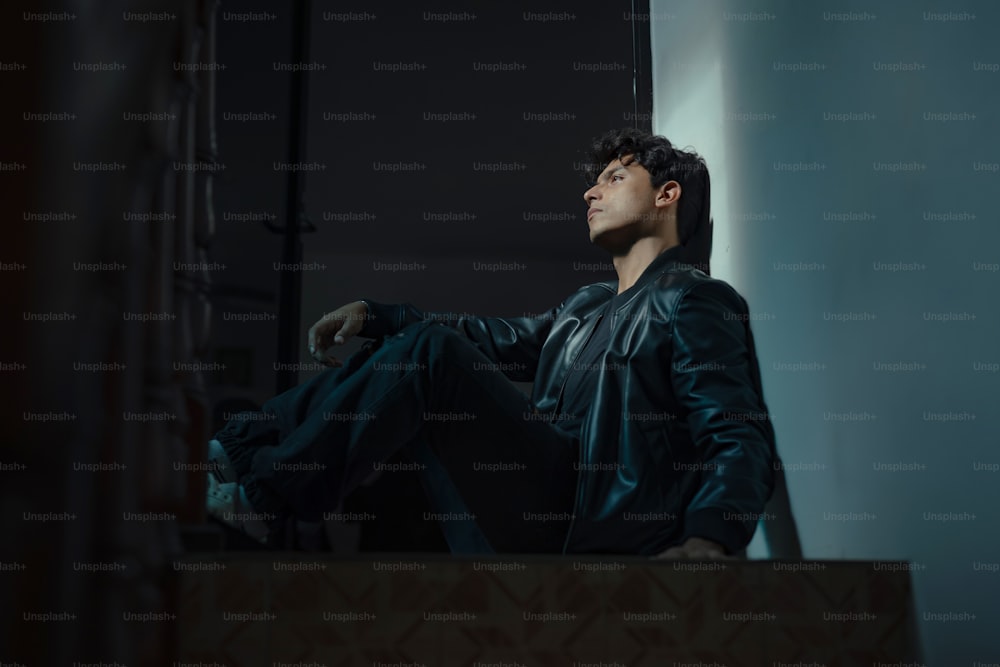 a man sitting on a ledge in a dark room