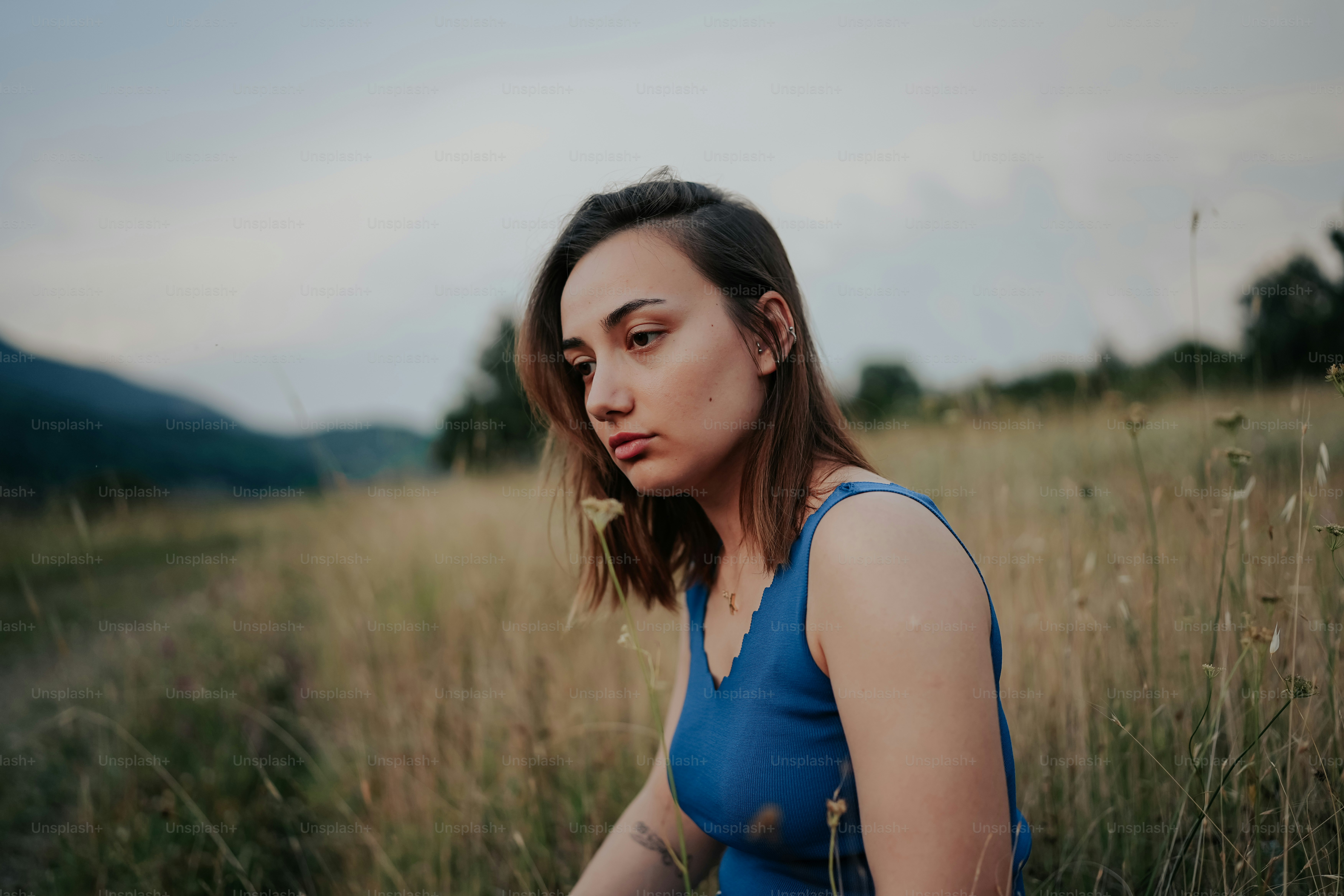 a woman sitting in a field of tall grass