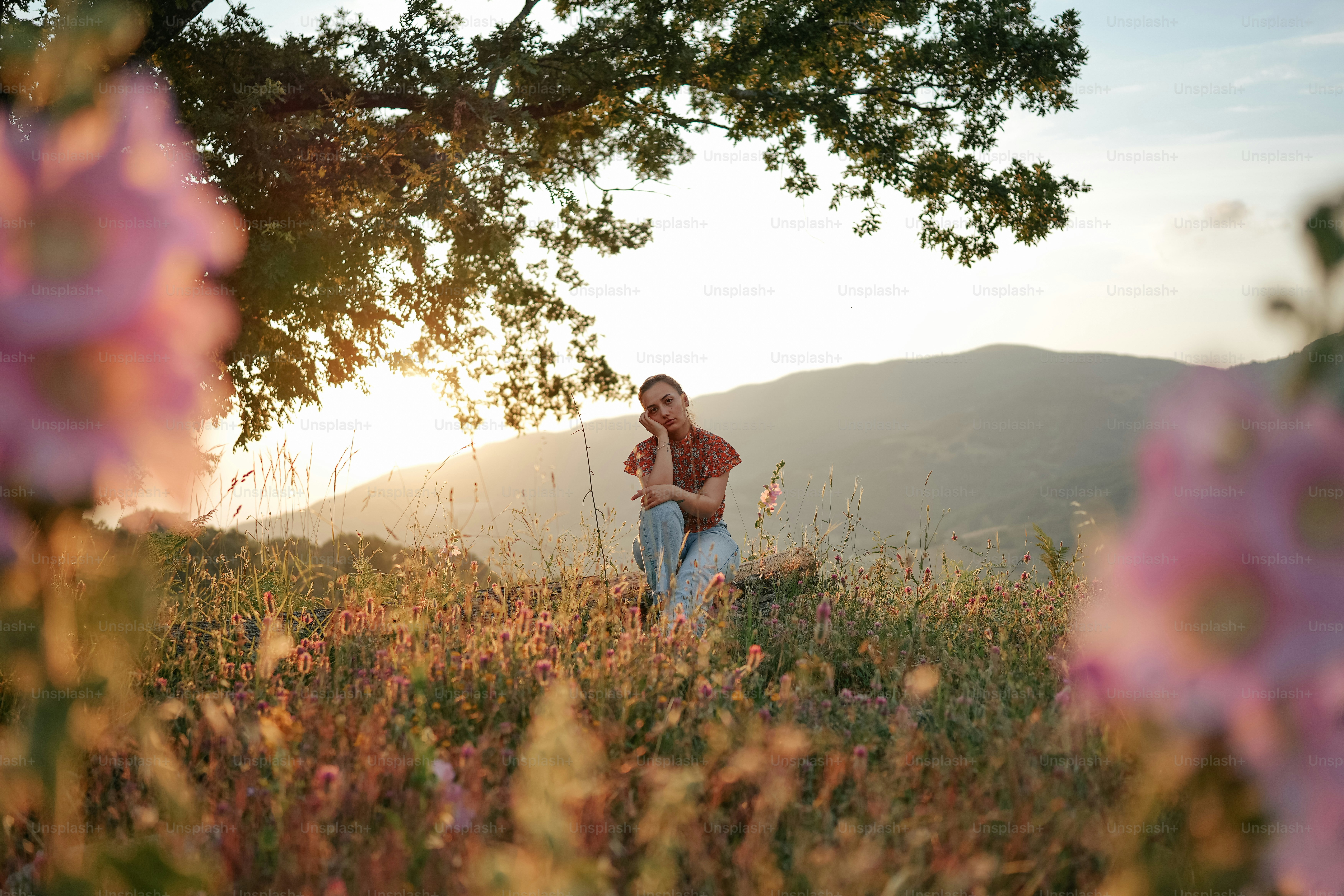 a man is sitting in a field of flowers
