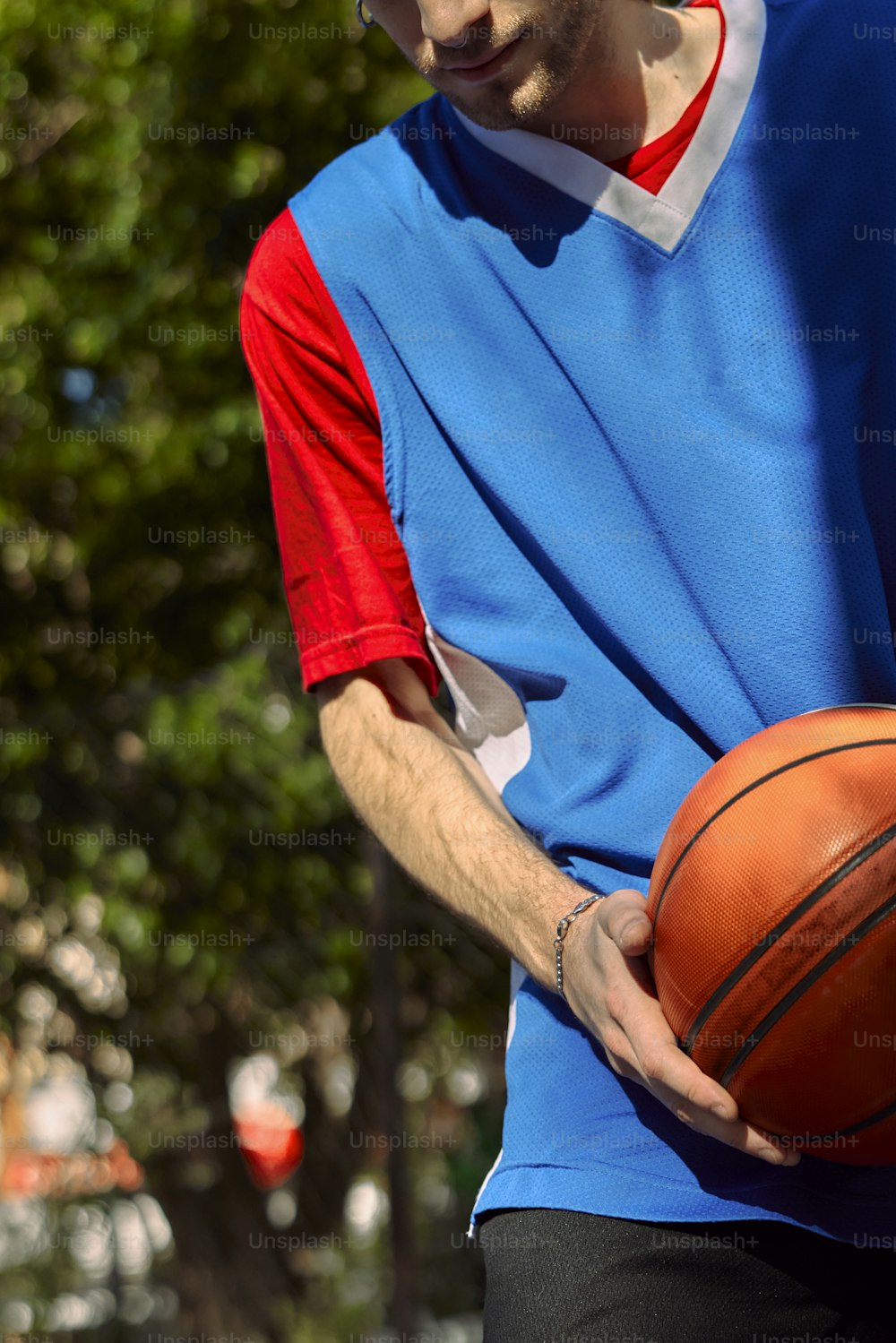 Un hombre sosteniendo una pelota de baloncesto en su mano derecha