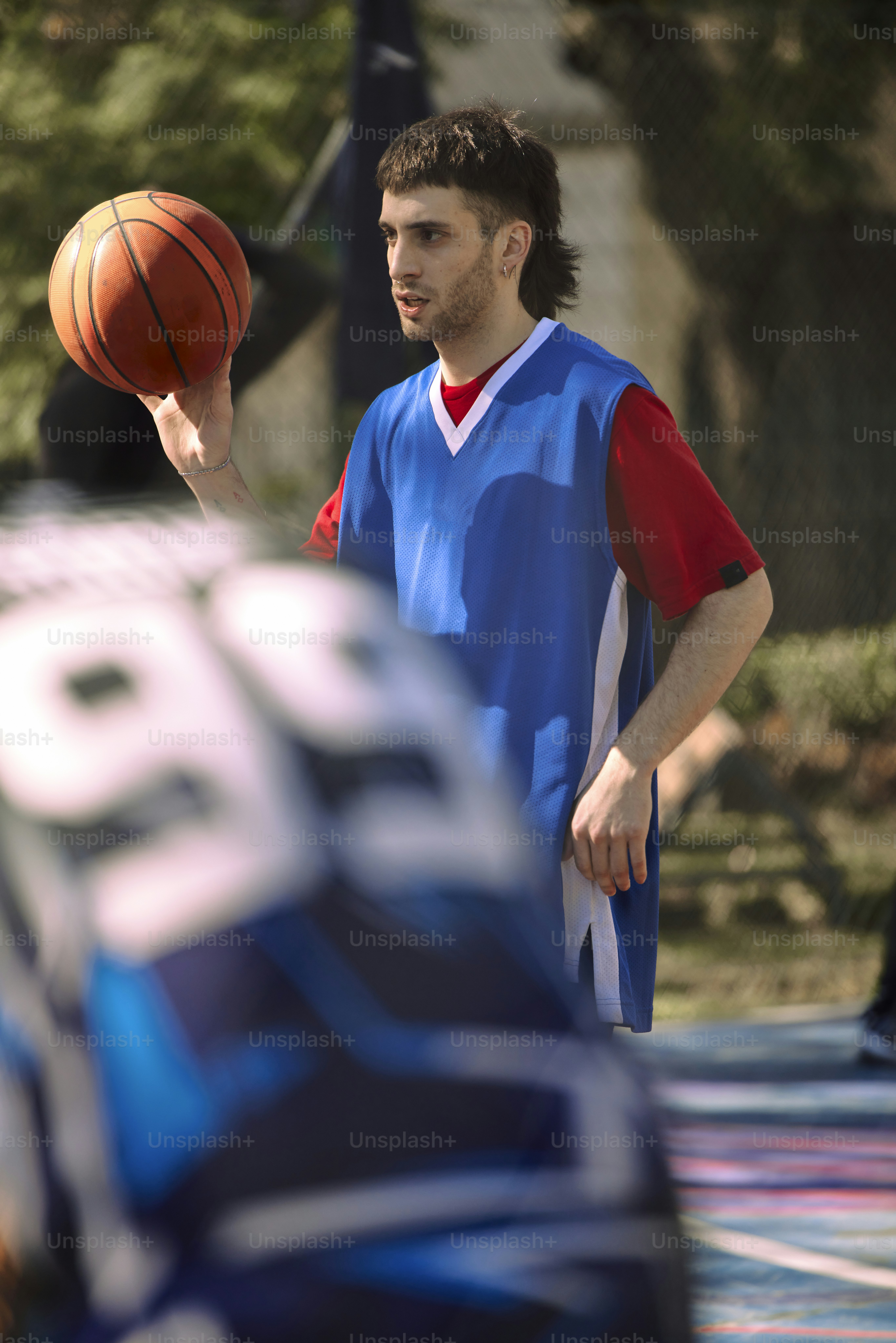 Un uomo che tiene un pallone da basket nella mano destra