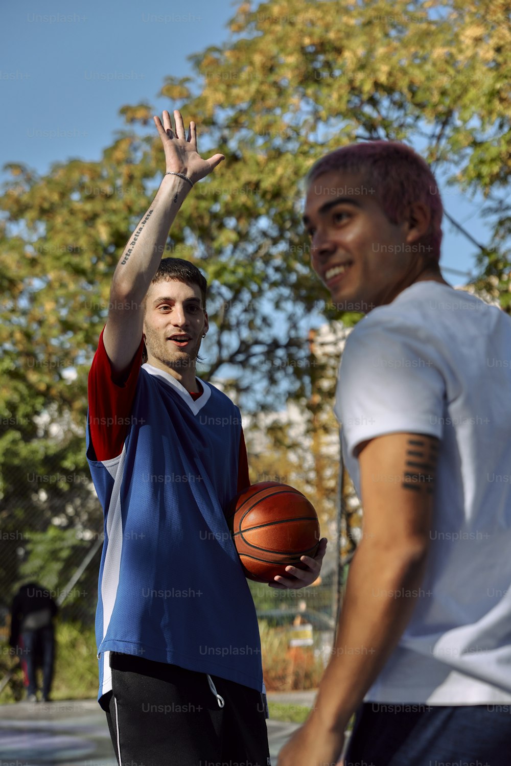 a man holding a basketball in front of another man