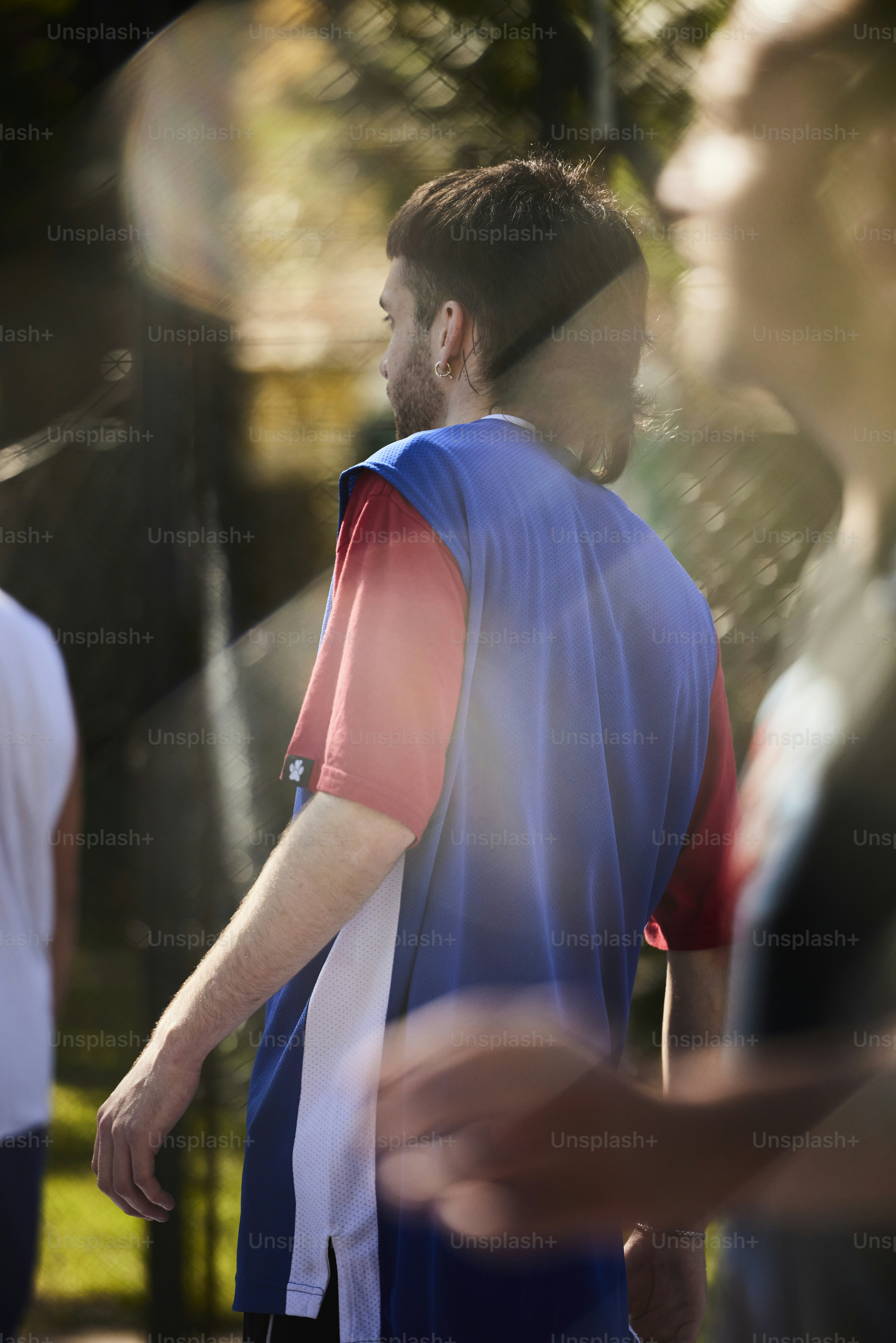 Un uomo con una camicia blu e rossa sta camminando