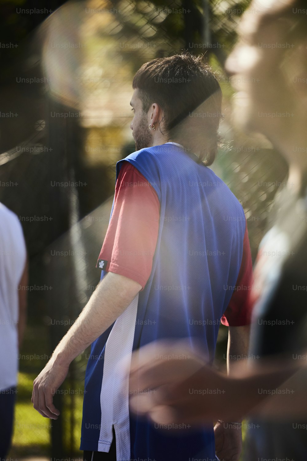 a man in a blue and red shirt is walking