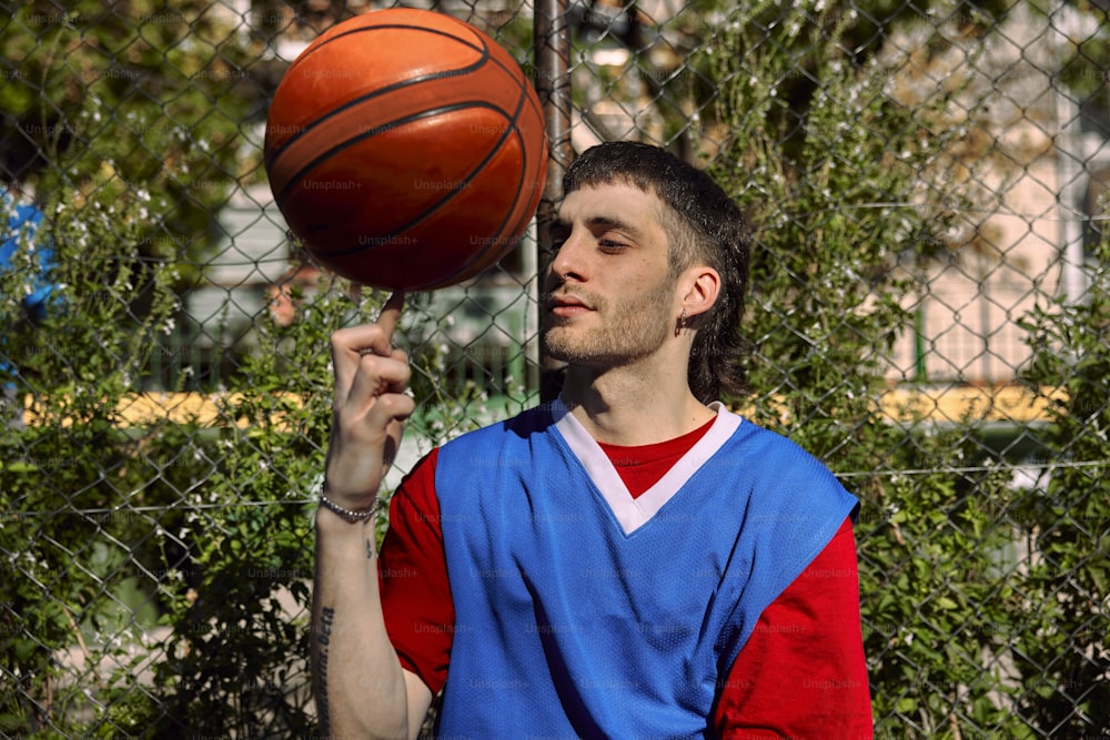 ein mann, der sich einen basketball vors gesicht hält