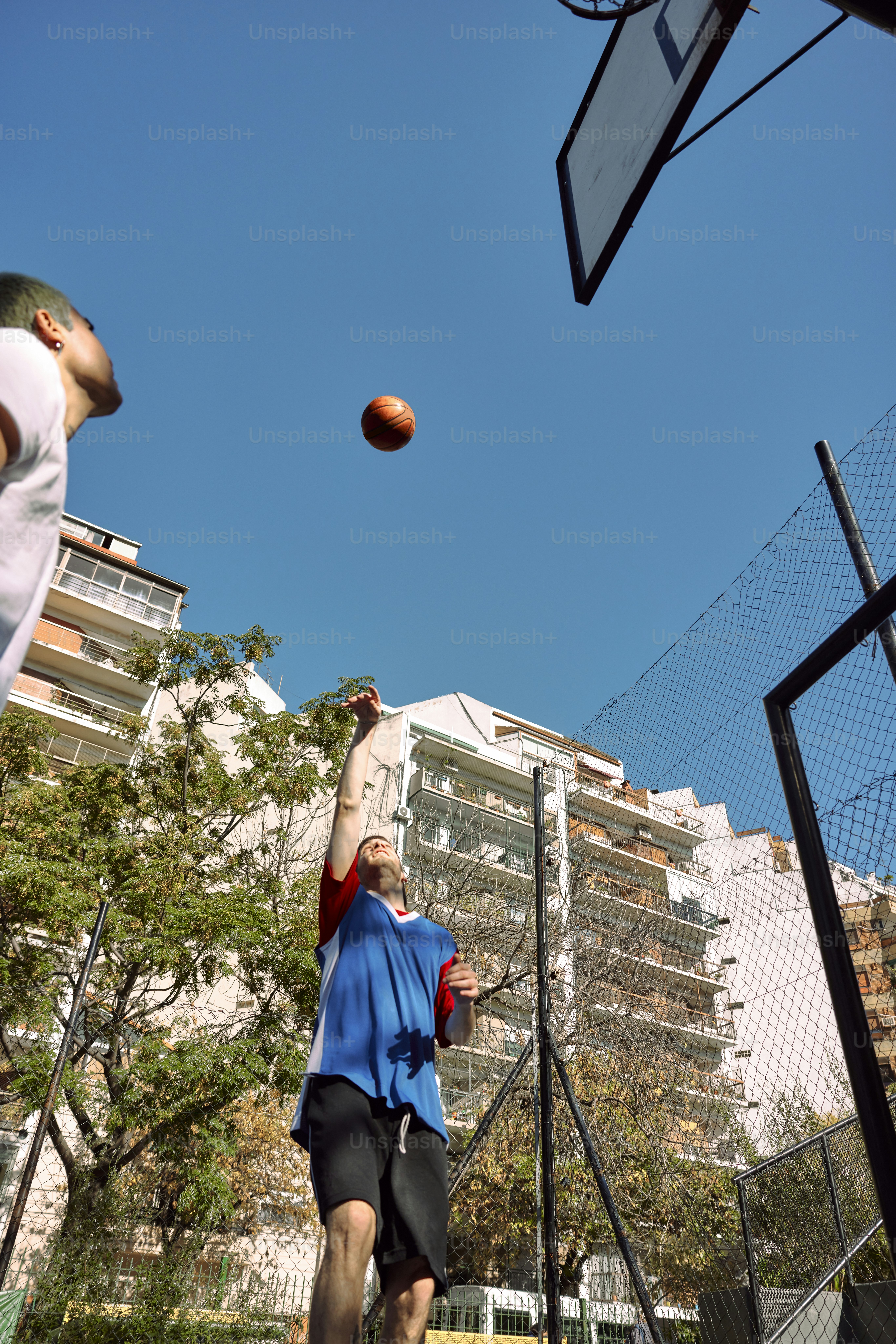 A man throwing a ball up into the air photo Basketball Image on Unsplash