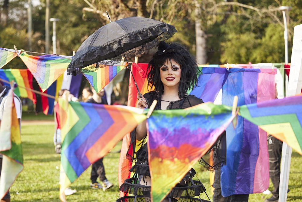 a woman holding a black umbrella in a field