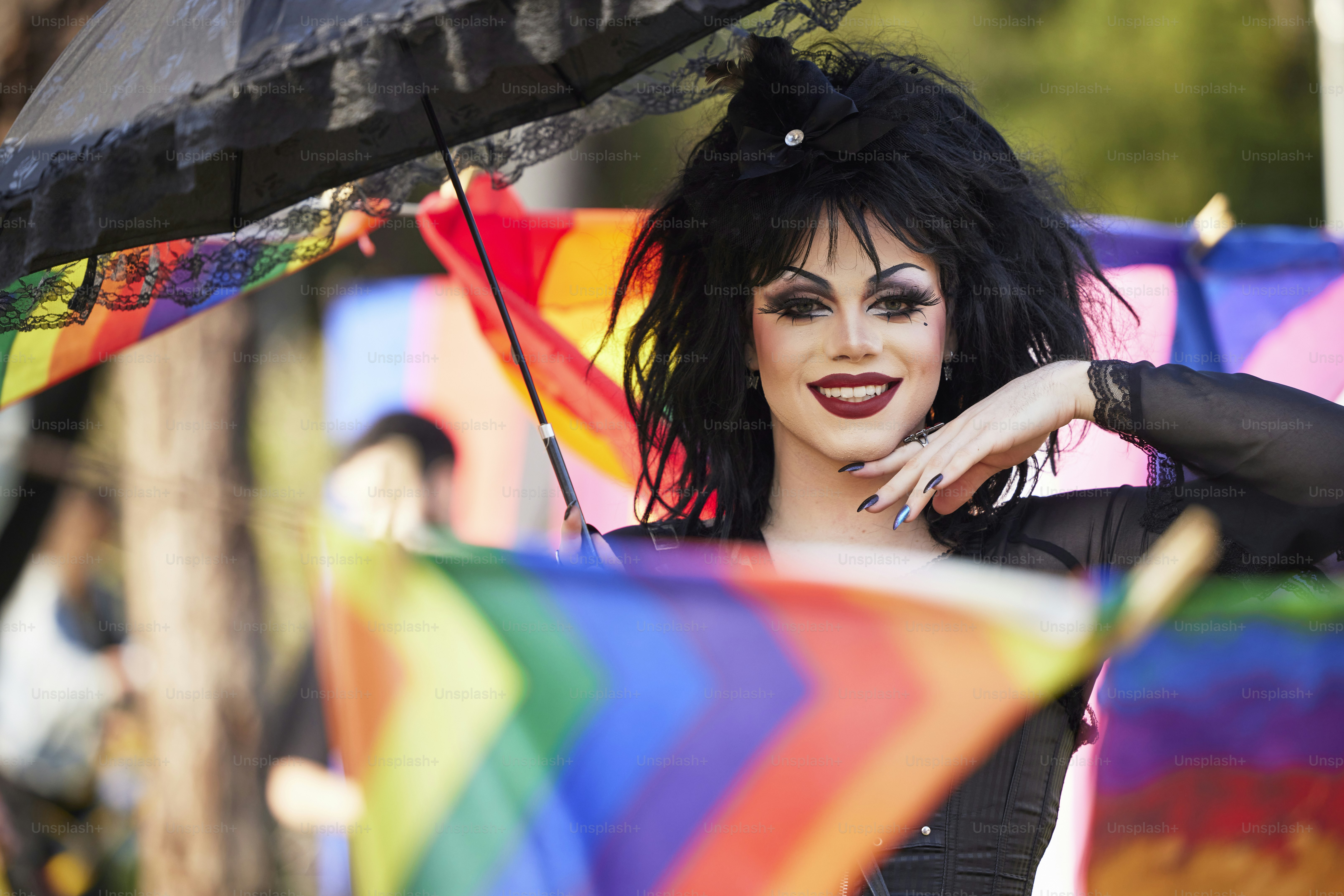 a woman in a black outfit holding an umbrella