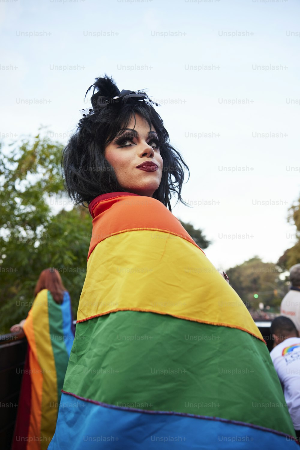 a woman wearing a rainbow colored jacket and black hair