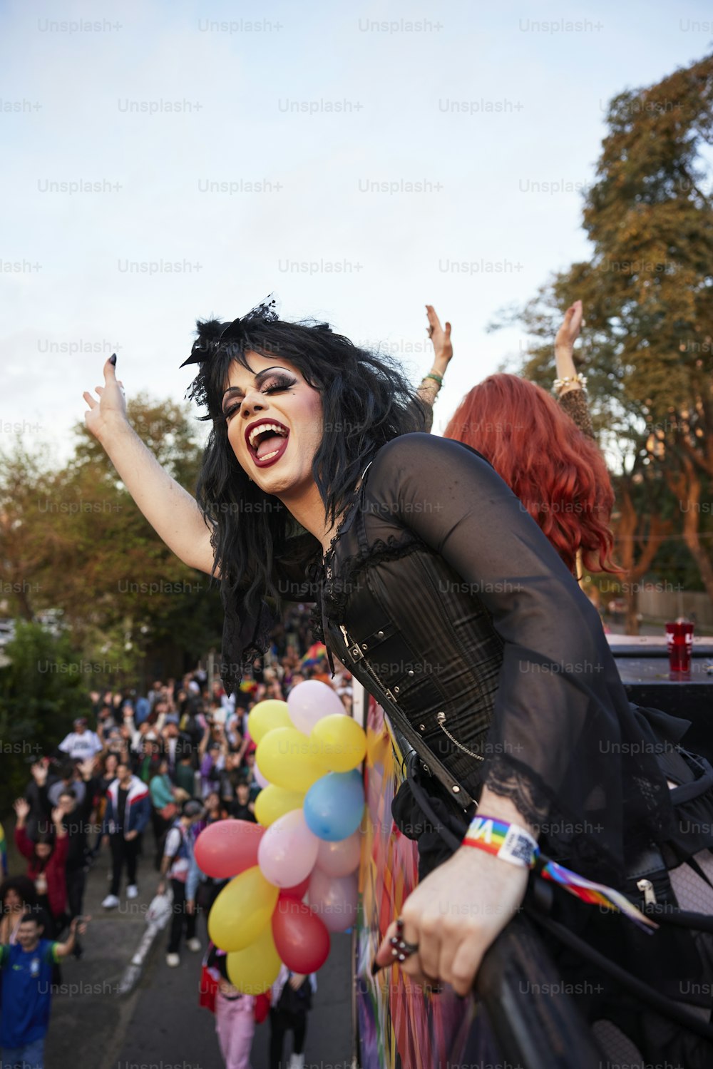 uma mulher com cabelo preto e maquiagem segurando um monte de balões