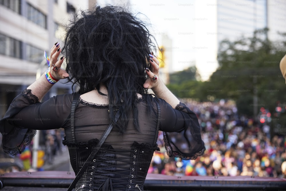 a woman with black hair is standing in front of a crowd