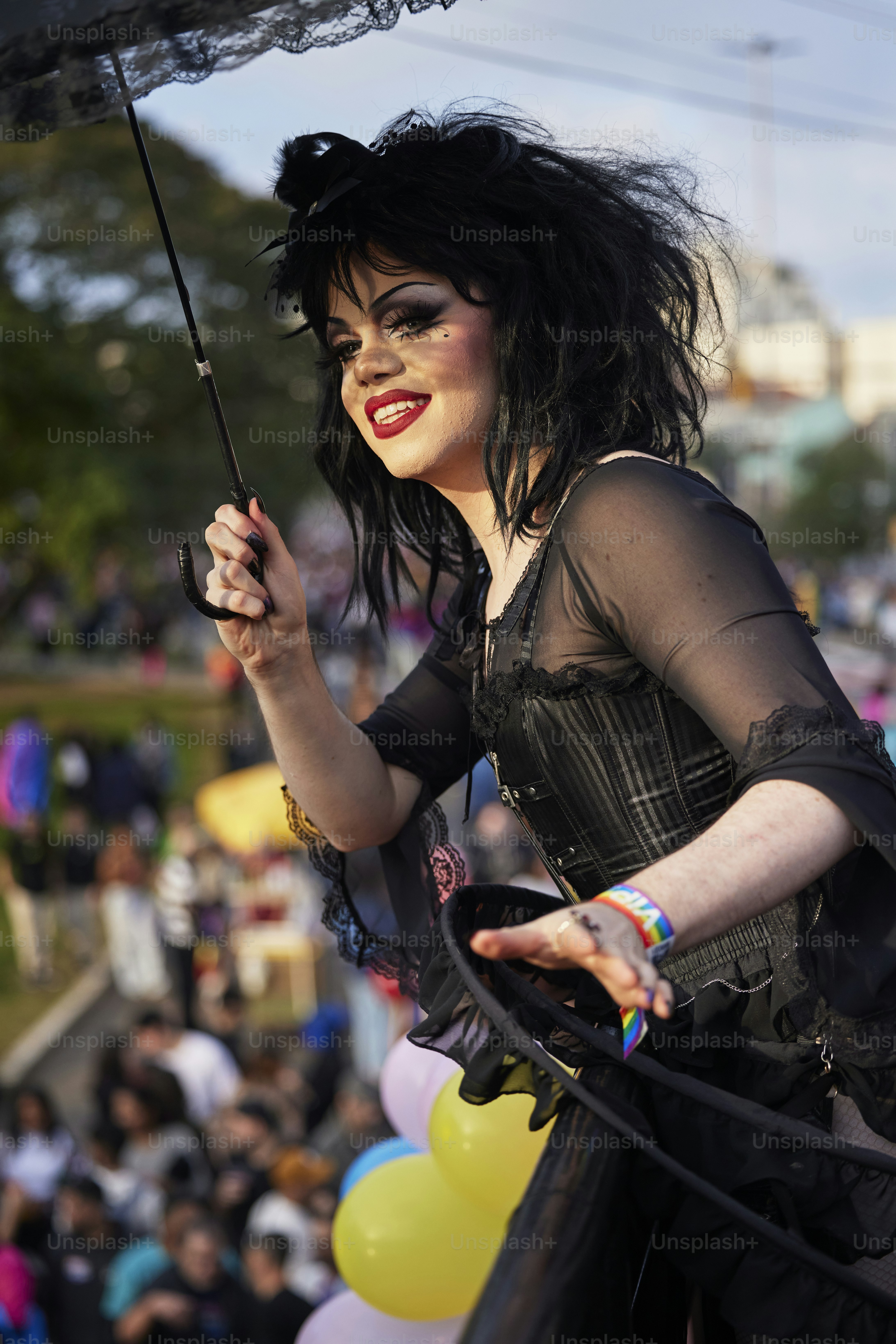 a woman in a black dress holding an umbrella