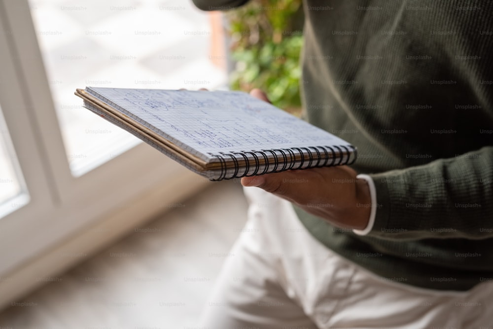 a person holding a notebook in their hand