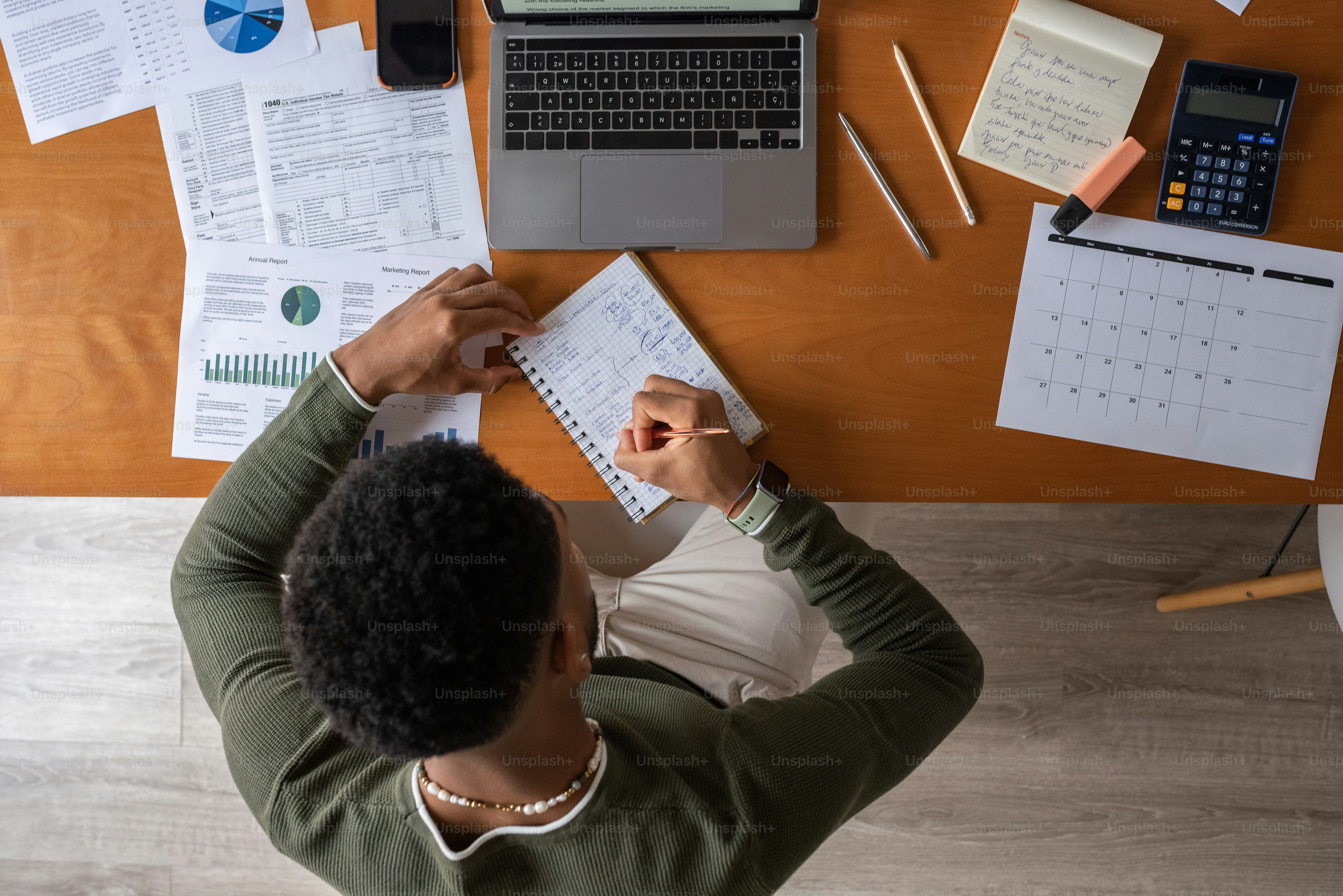 una persona seduta a una scrivania con un computer portatile e documenti