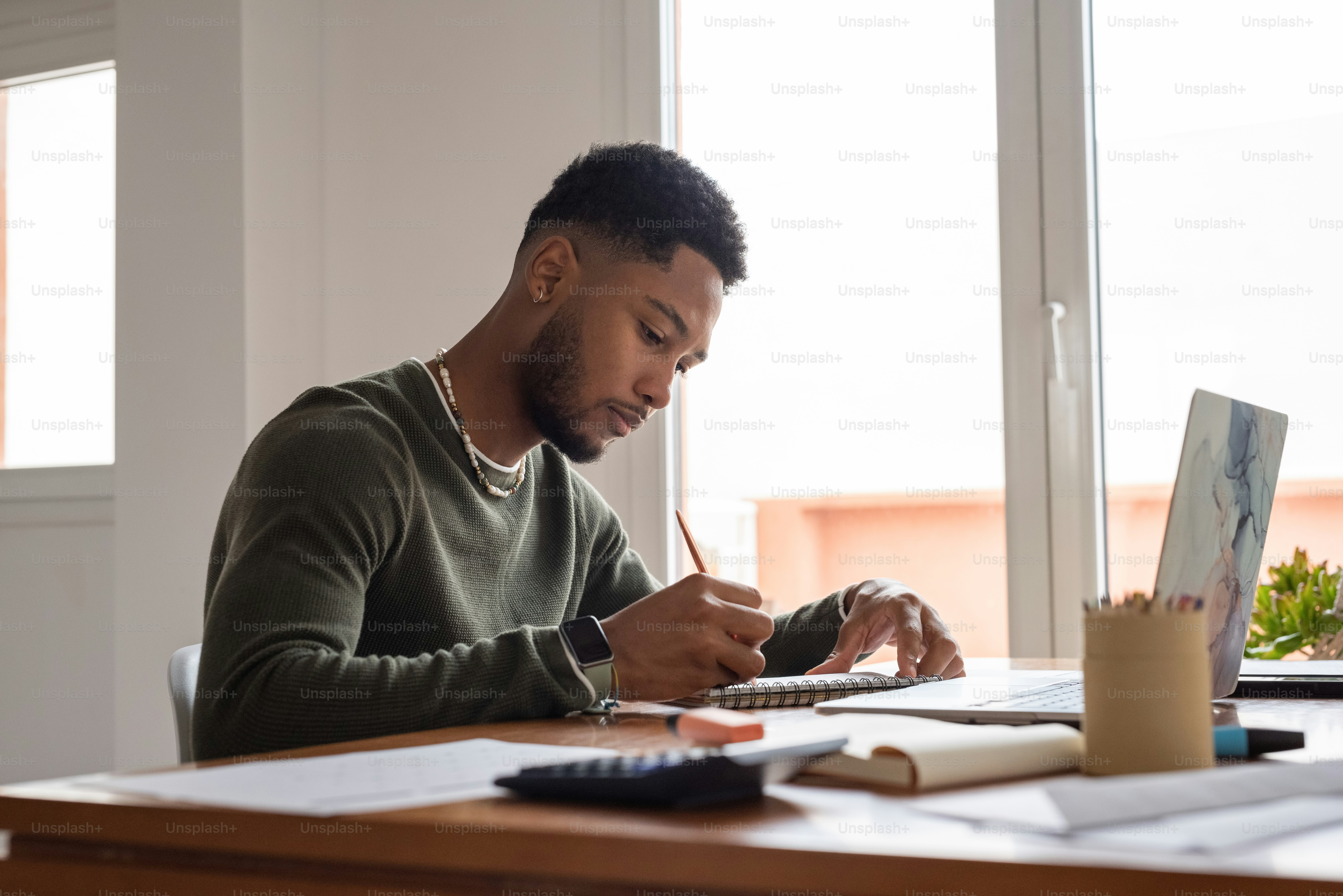 Un hombre sentado en un escritorio trabajando en una computadora portátil
