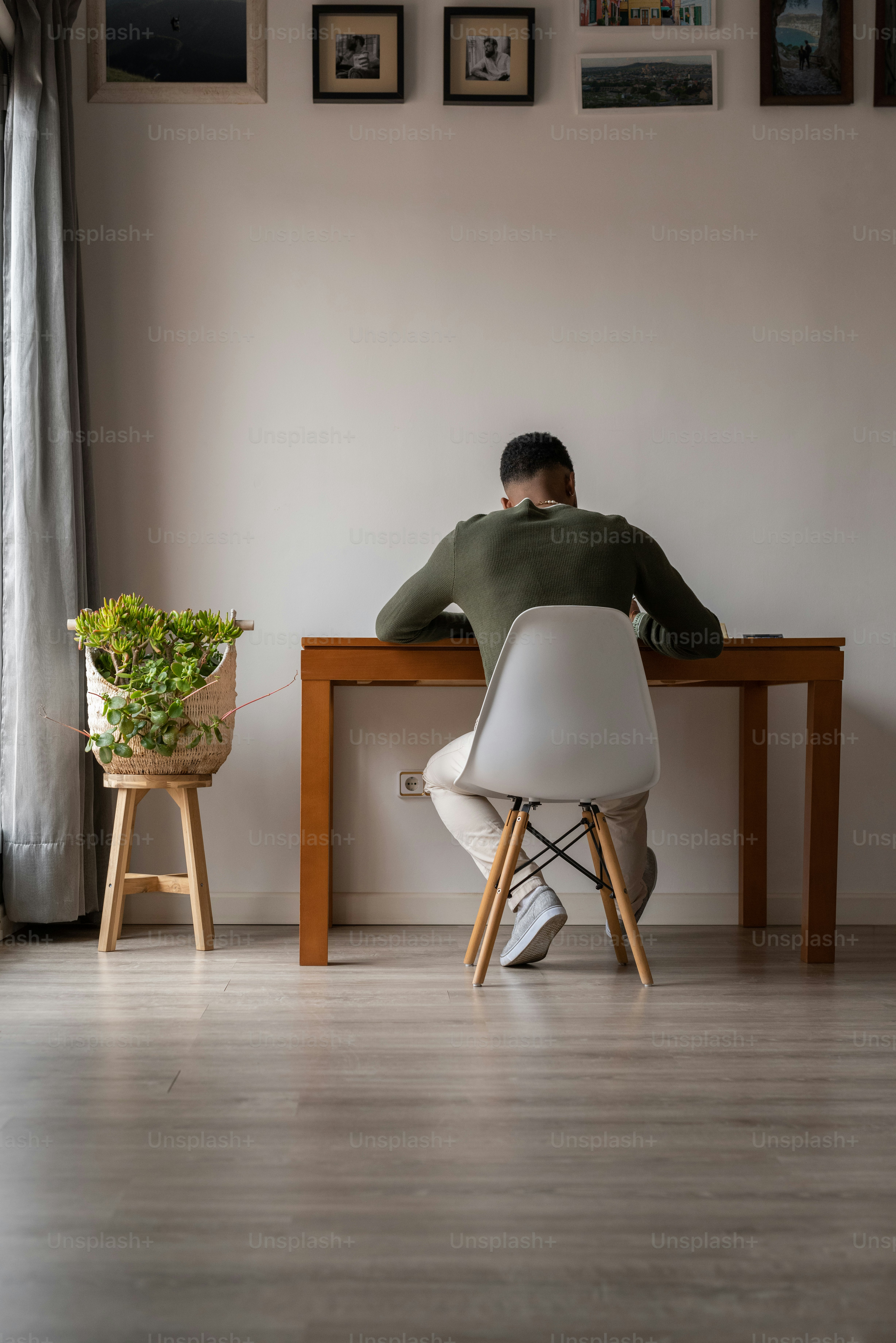 un uomo seduto a un tavolo con una pianta in vaso