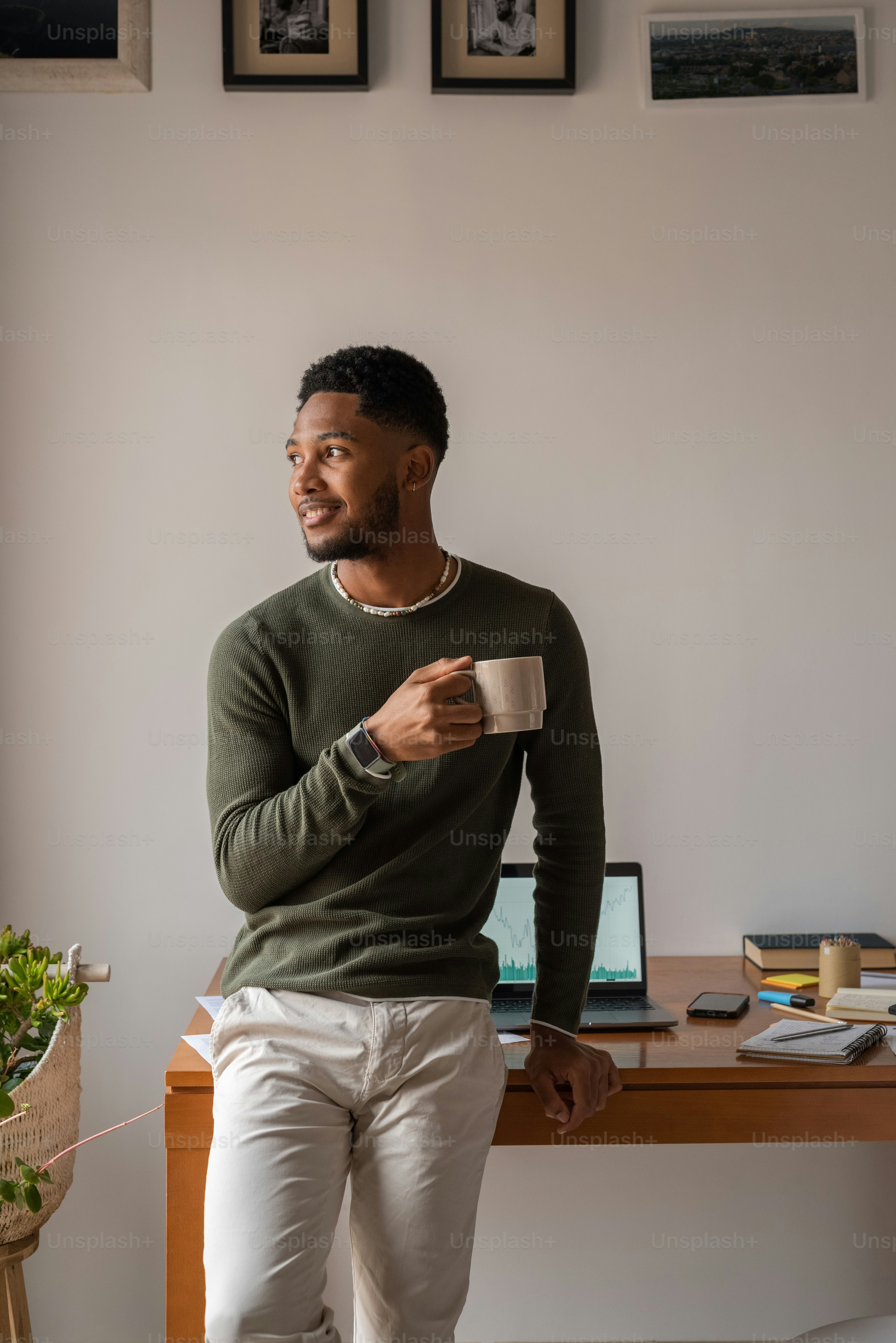Un uomo seduto a una scrivania con in mano una tazza di caffè