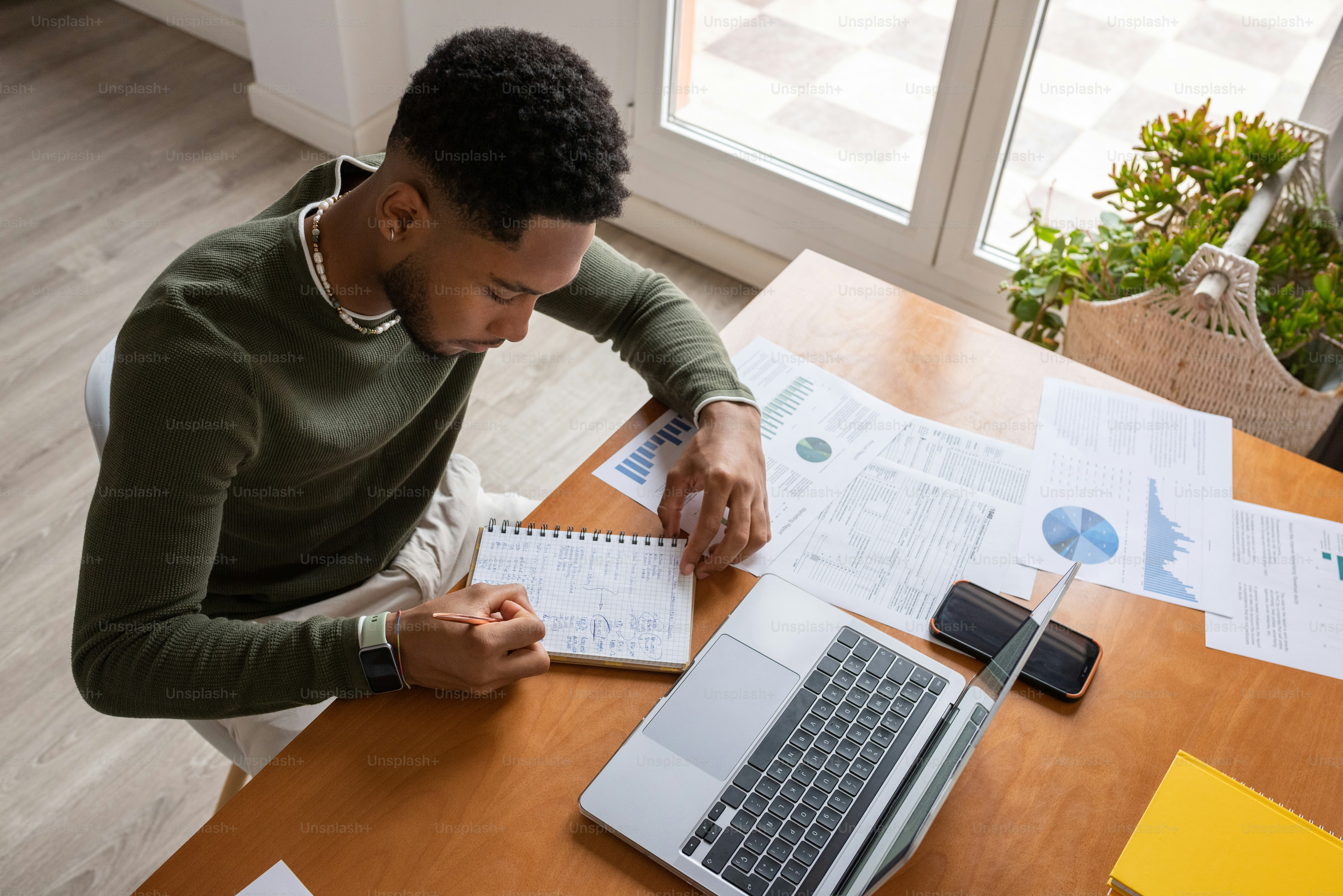 um homem sentado em uma mesa trabalhando em um laptop