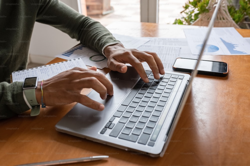 Una persona escribiendo en una computadora portátil en un escritorio