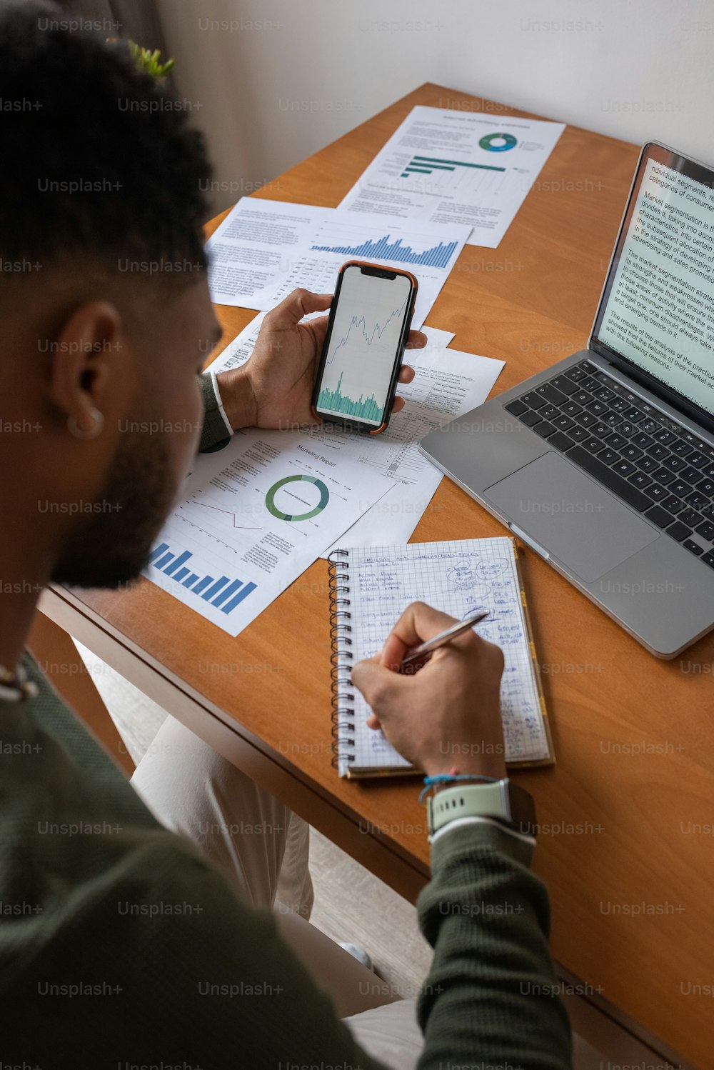 Un homme assis à un bureau avec des papiers et un ordinateur portable